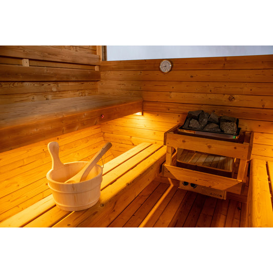 Wooden sauna interior with a bucket and ladle, bench, and stove.