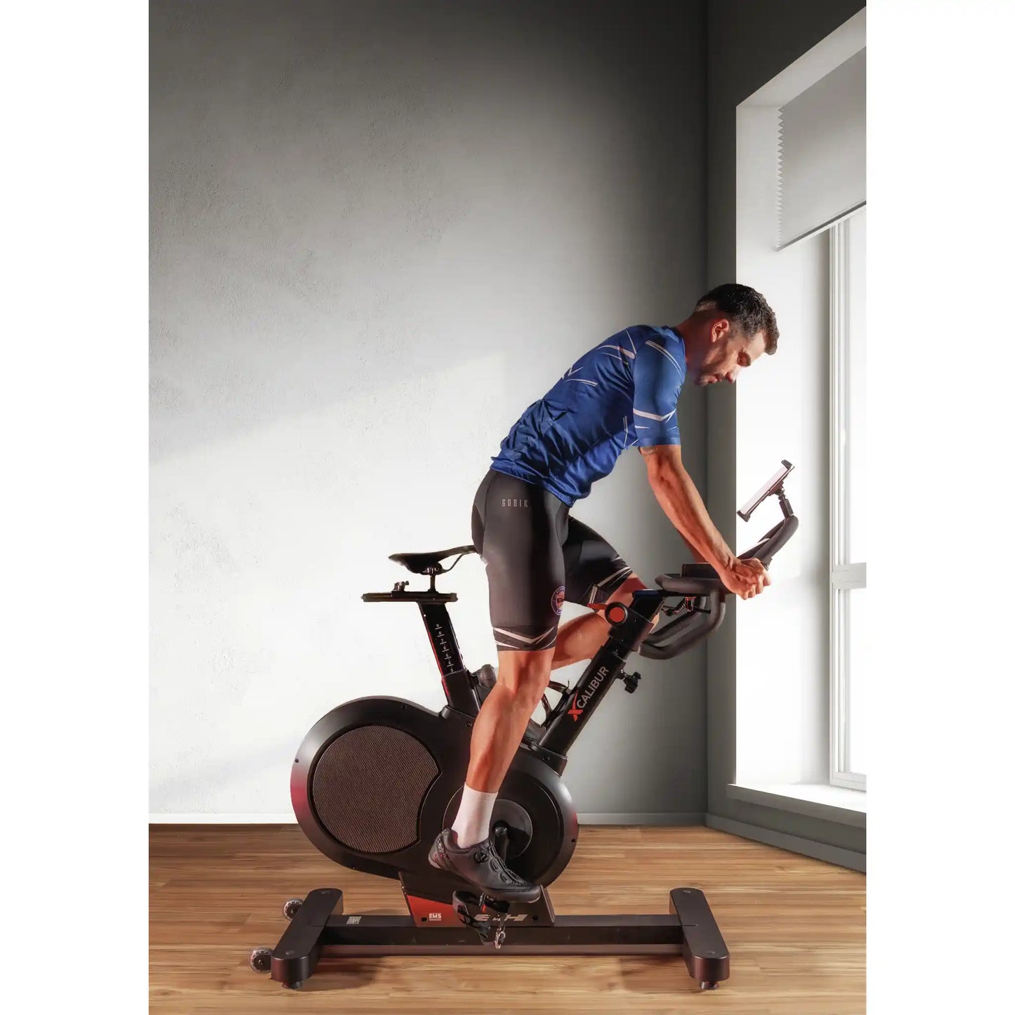Man exercising on a stationary bike indoors.