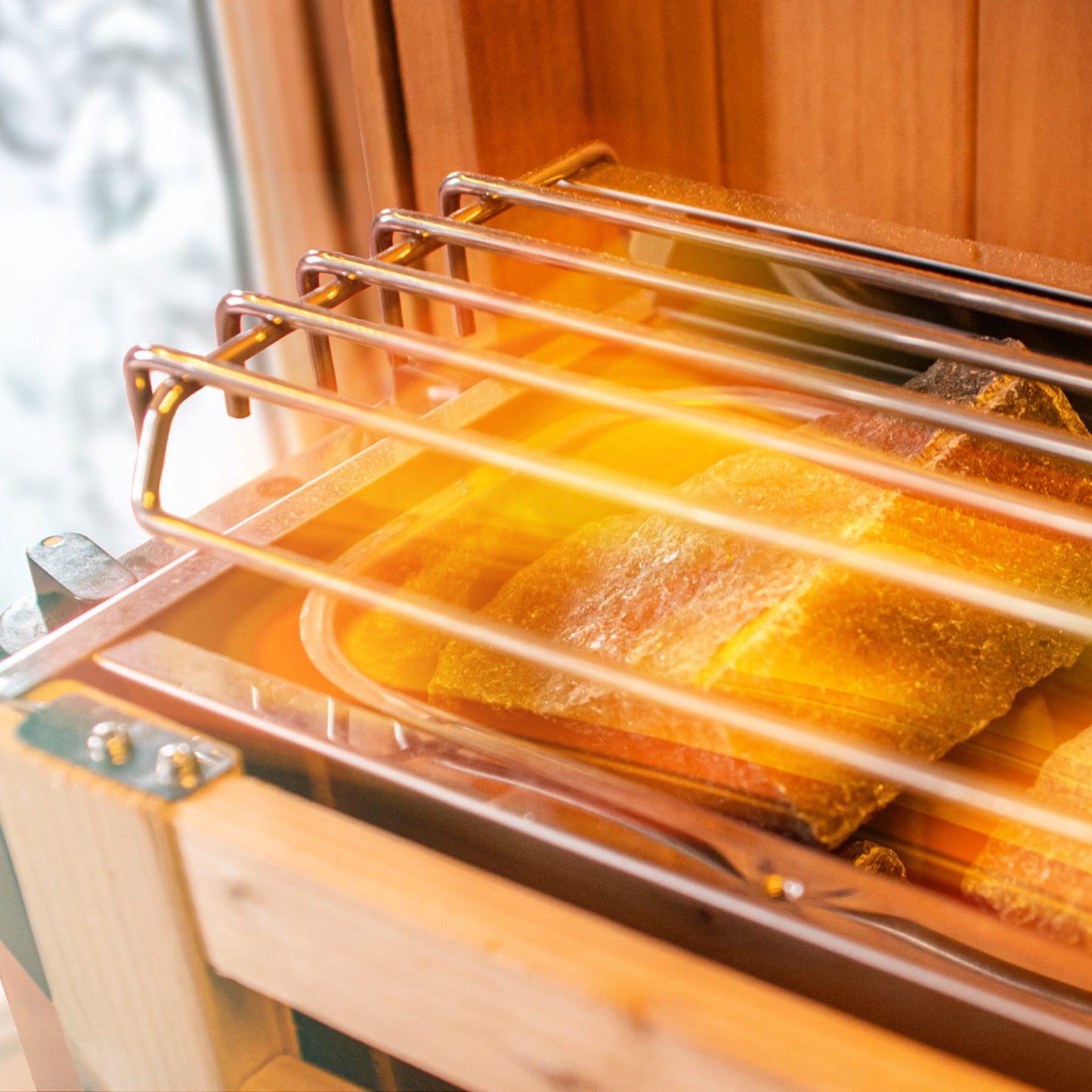 Wooden sauna with glass door showing top of stove