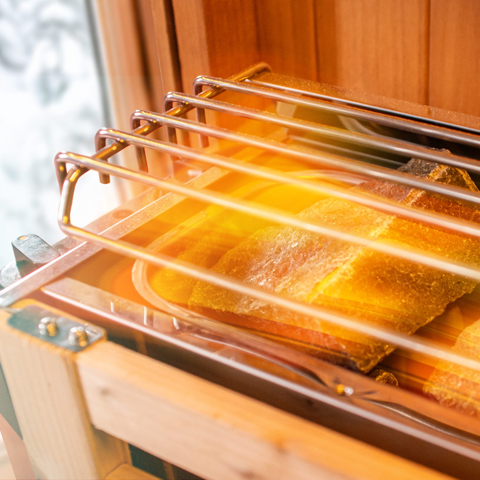 Wooden sauna with glass door showing top of stove