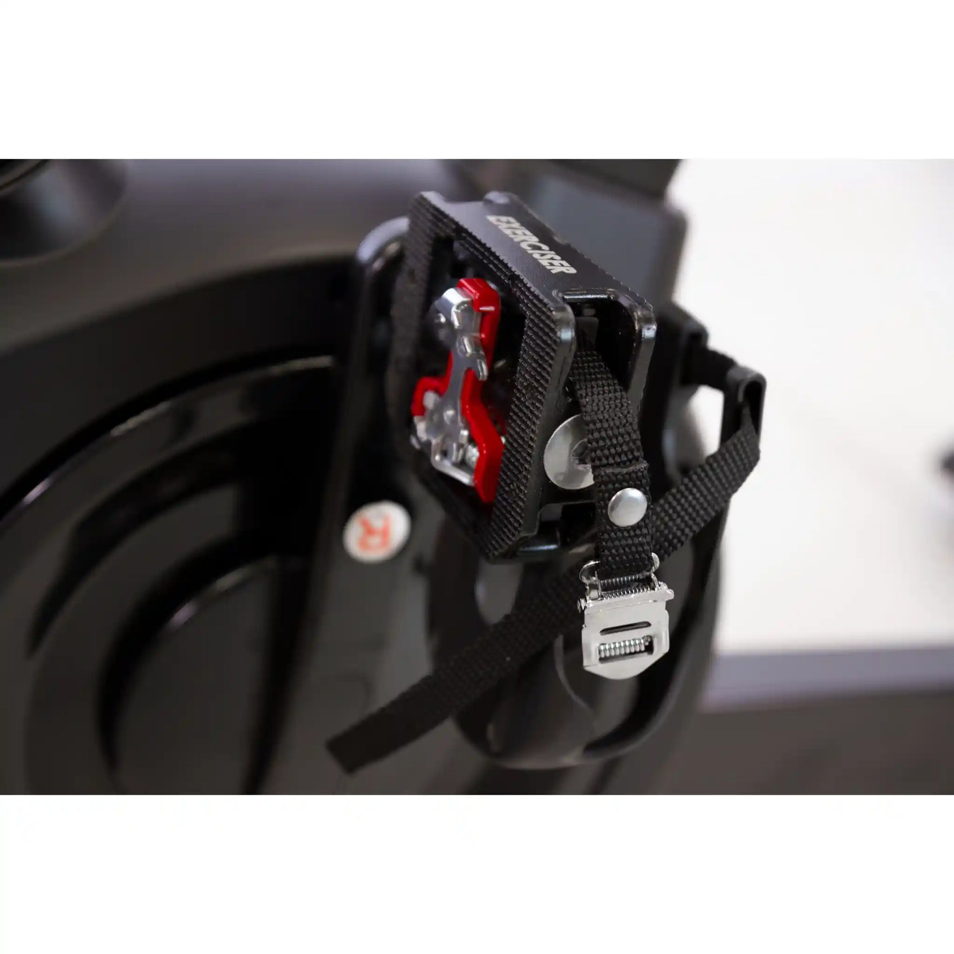 Close-up of a black bike pedals attached to a bicycle frame with a blurred background