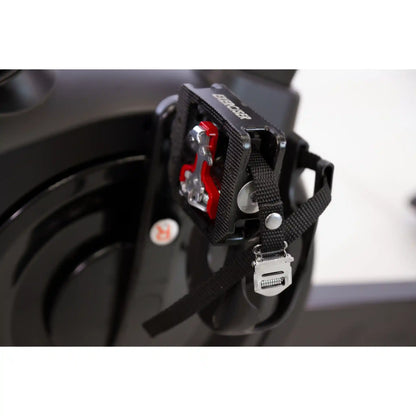 Close-up of a black bike pedals attached to a bicycle frame with a blurred background