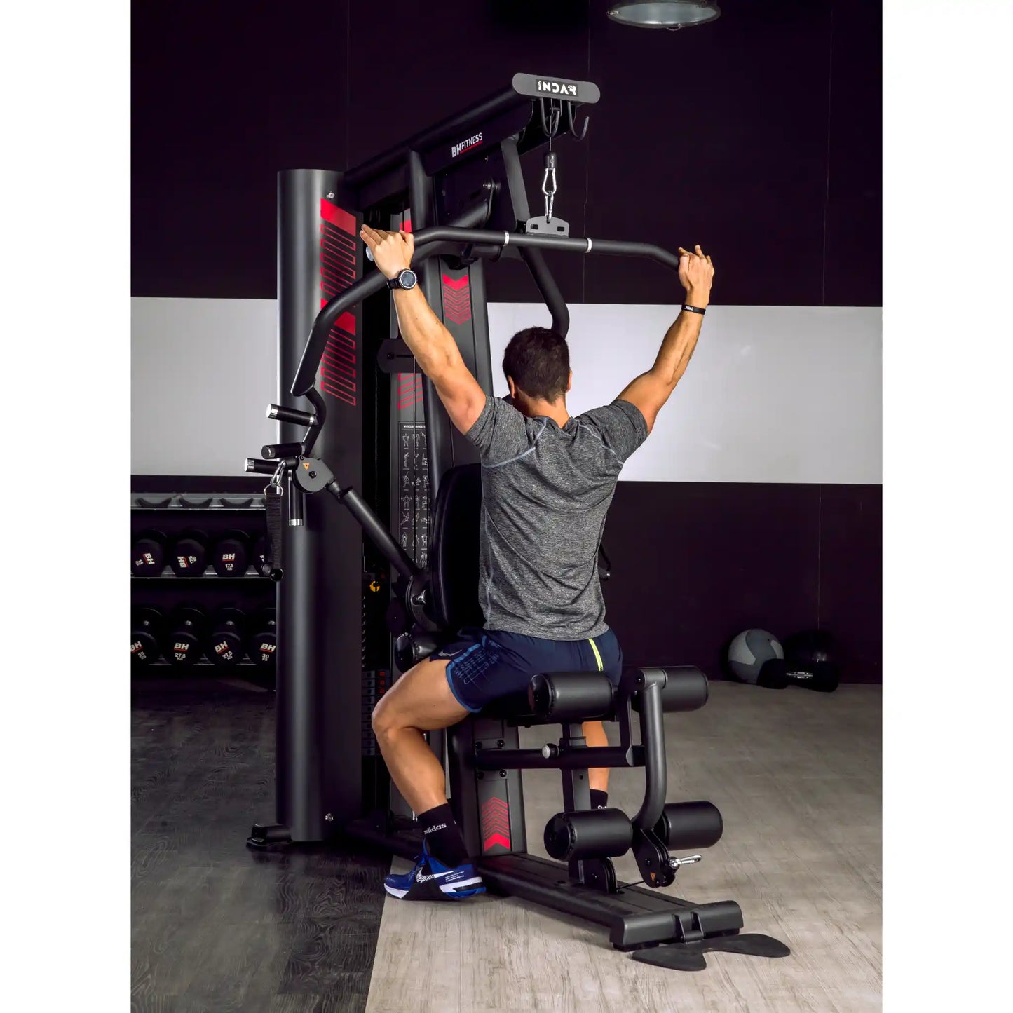 Man using lat pulldown function on multi gym