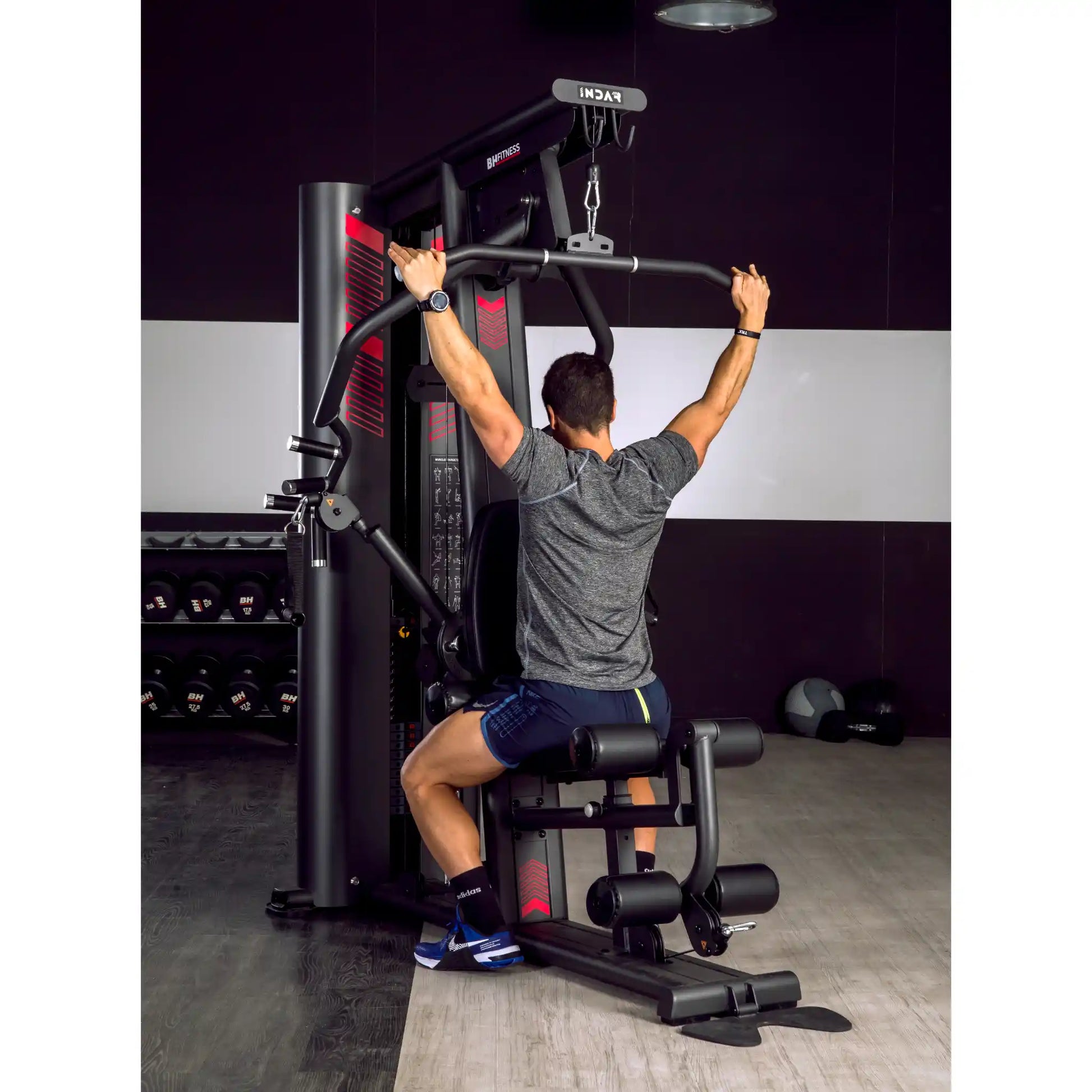 Man using lat pulldown function on multi gym