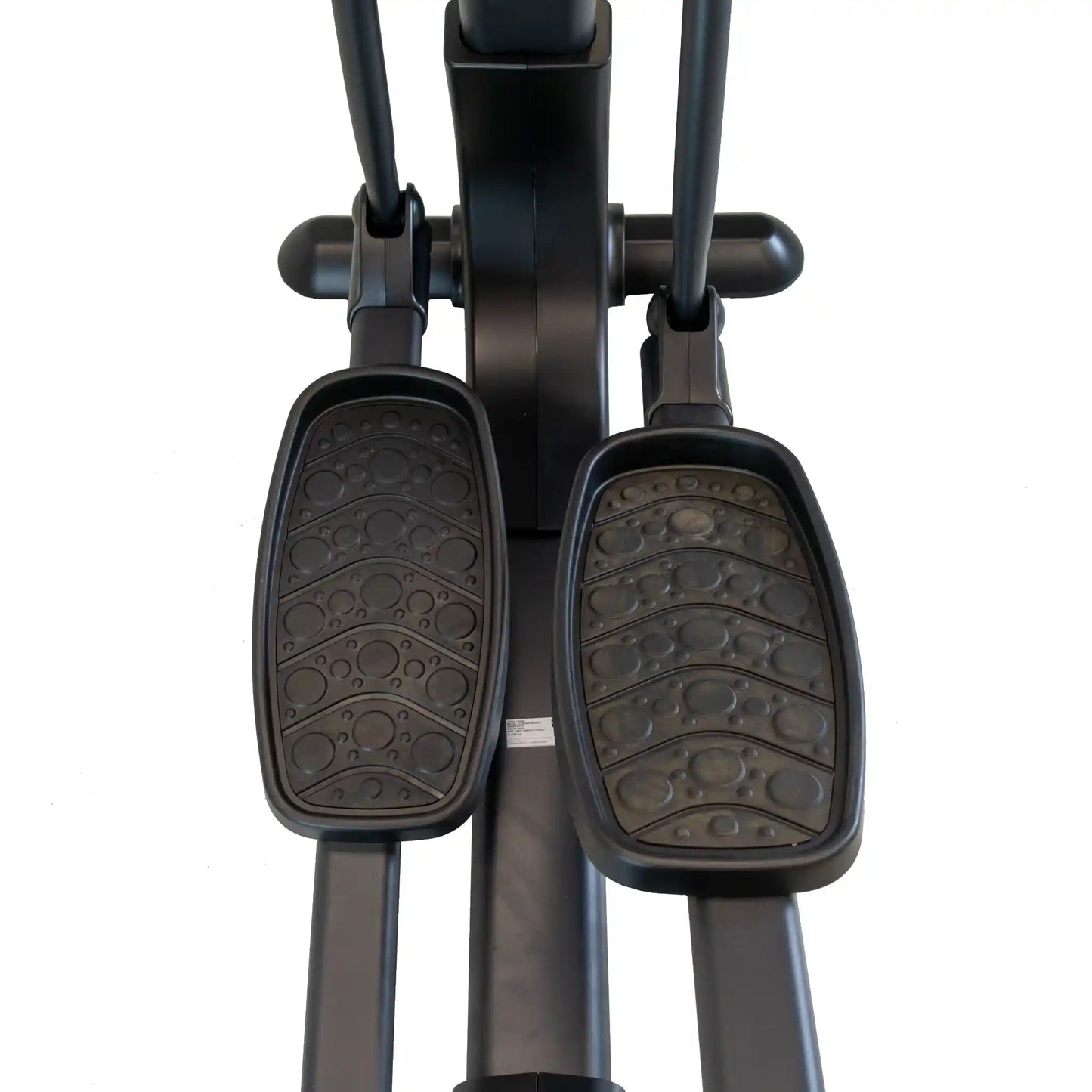 Close-up of black cross trainer machine pedals on a white background