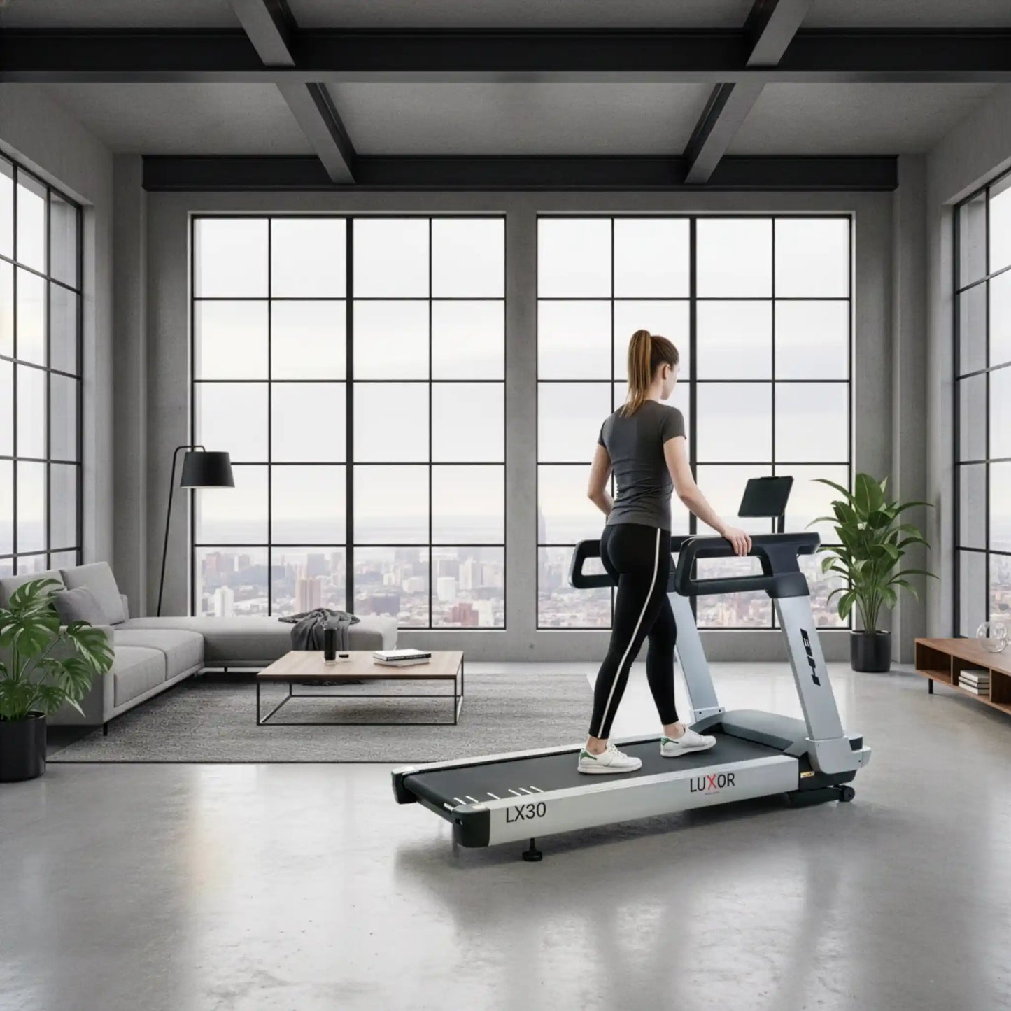 Woman using a treadmill in a modern living room with large windows.