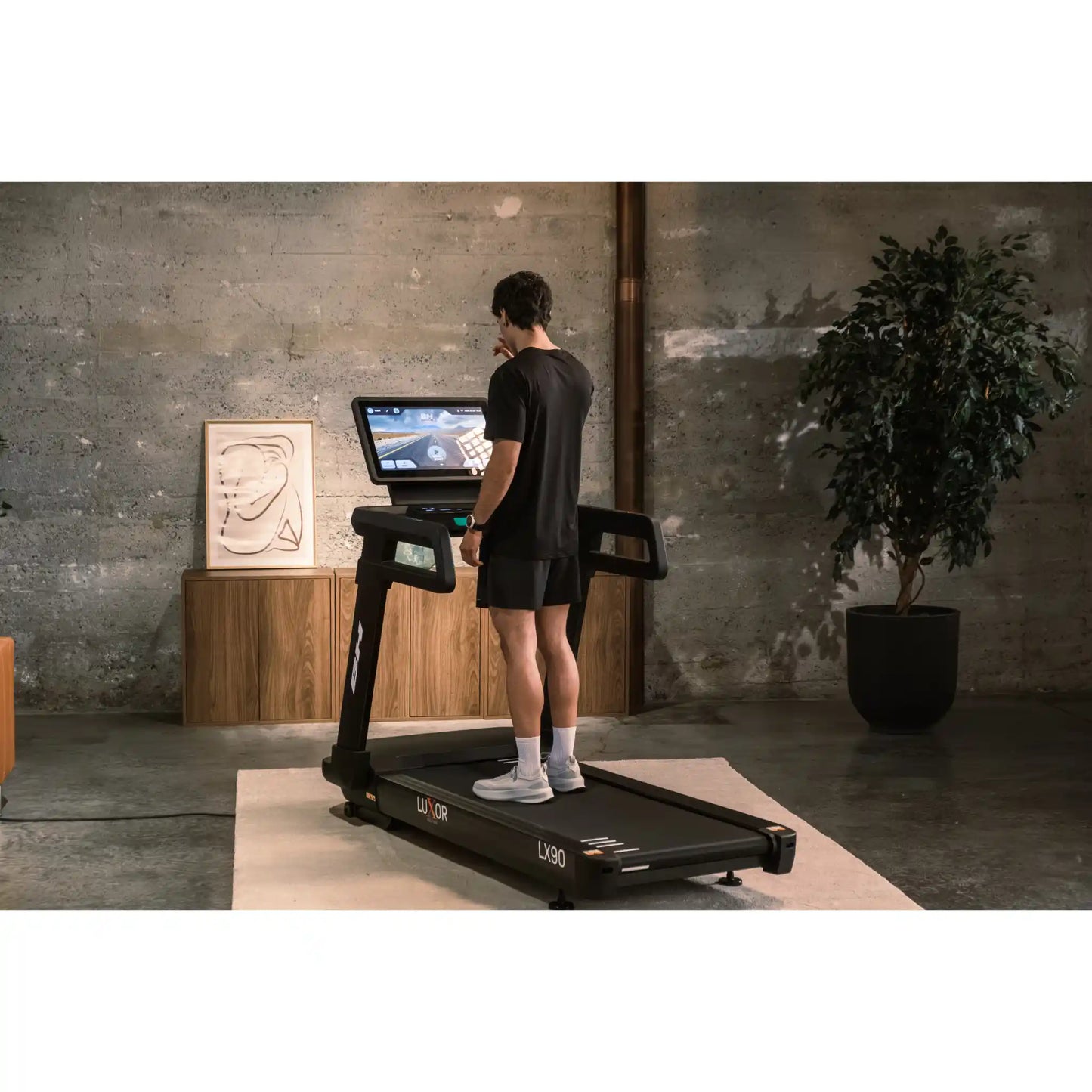 Person using a treadmill with a screen in a modern indoor setting