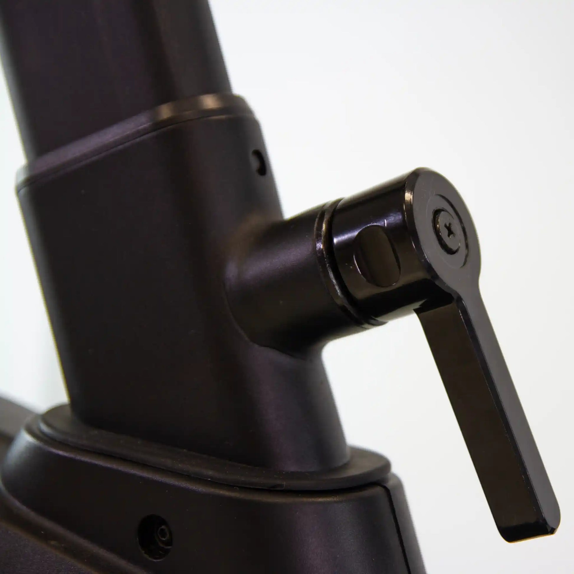Close-up of a black adjustable stand with a lever on a white background