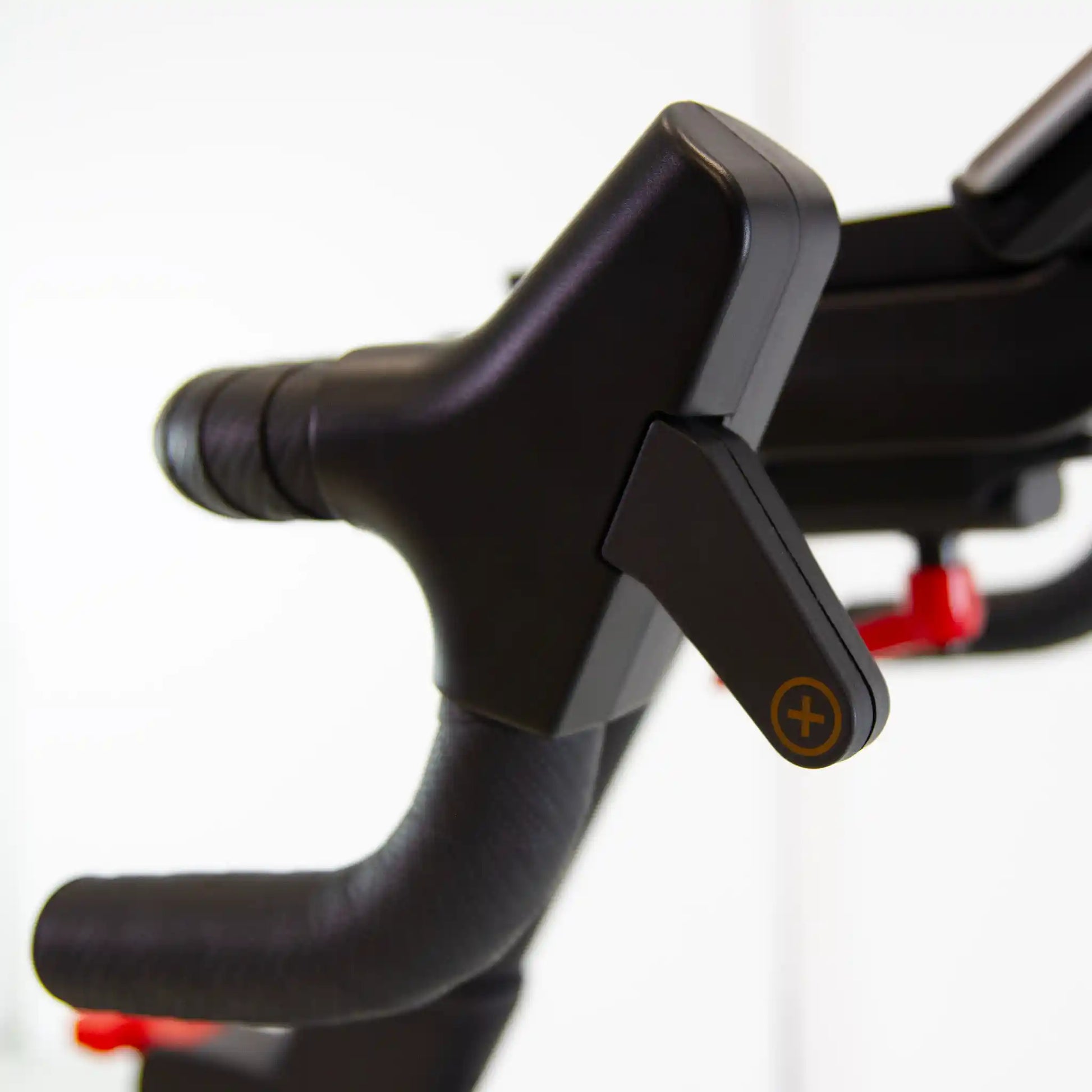 Close-up of a black bike handlebar with red accents on a white background