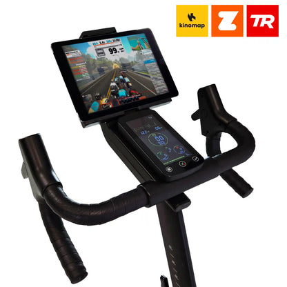 Exercise bike with a tablet displaying a cycling app on a white background, featuring Kinomap, Zortrax, and TR logos.