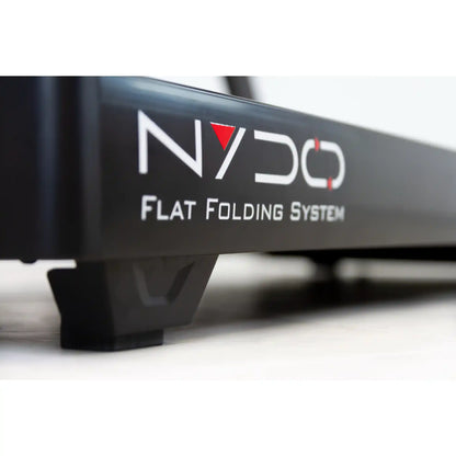 Close-up of deck of a treadmill with wording flat folding system and 'NYDO' branding on a white background