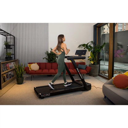 Woman using a treadmill in a modern living room.