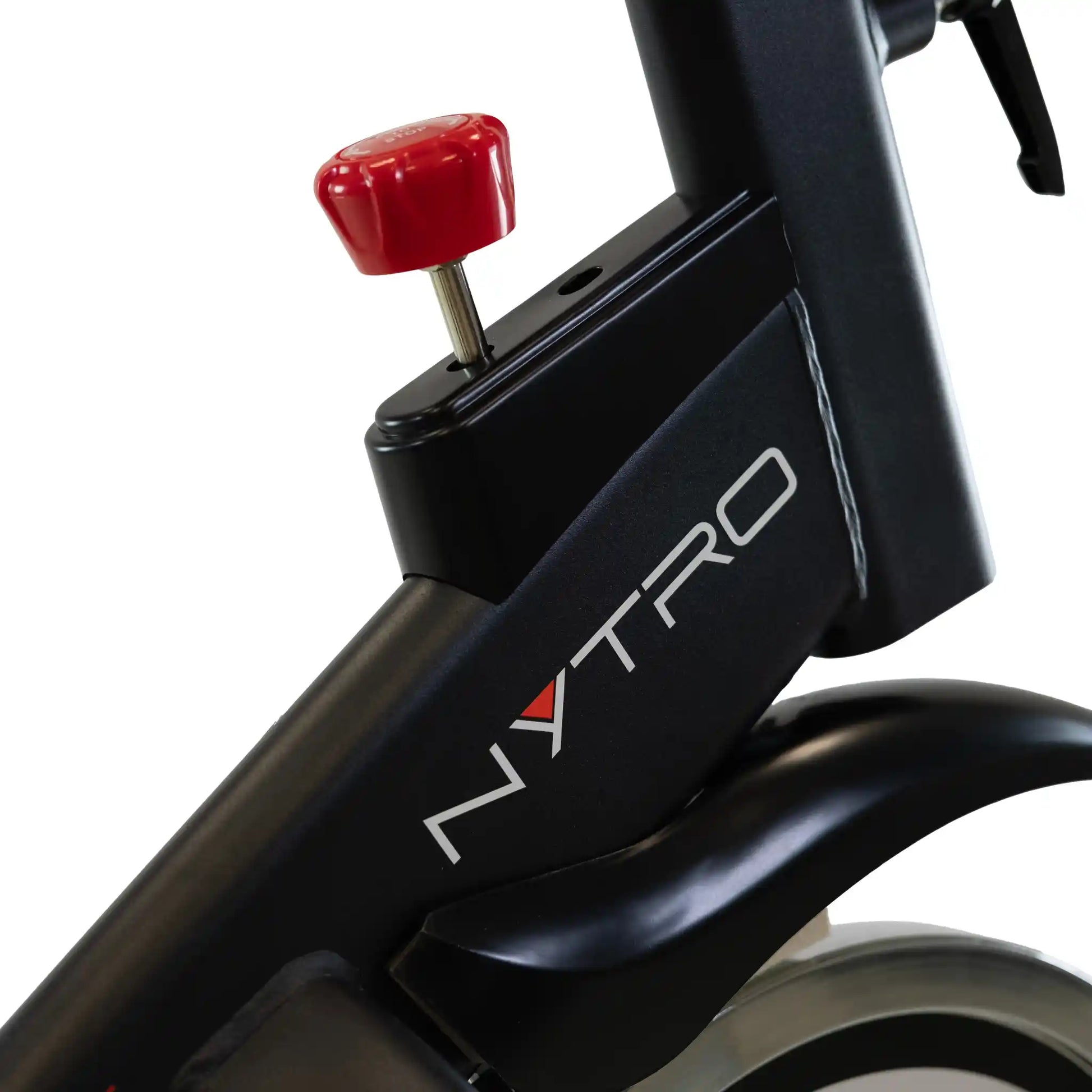 Close-up of a black exercise bike with a red component on a white background