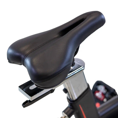 Black bicycle seat on a stationary bike with a white background