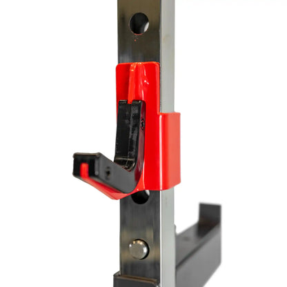 Red and black metal hook on weight bench with a white background