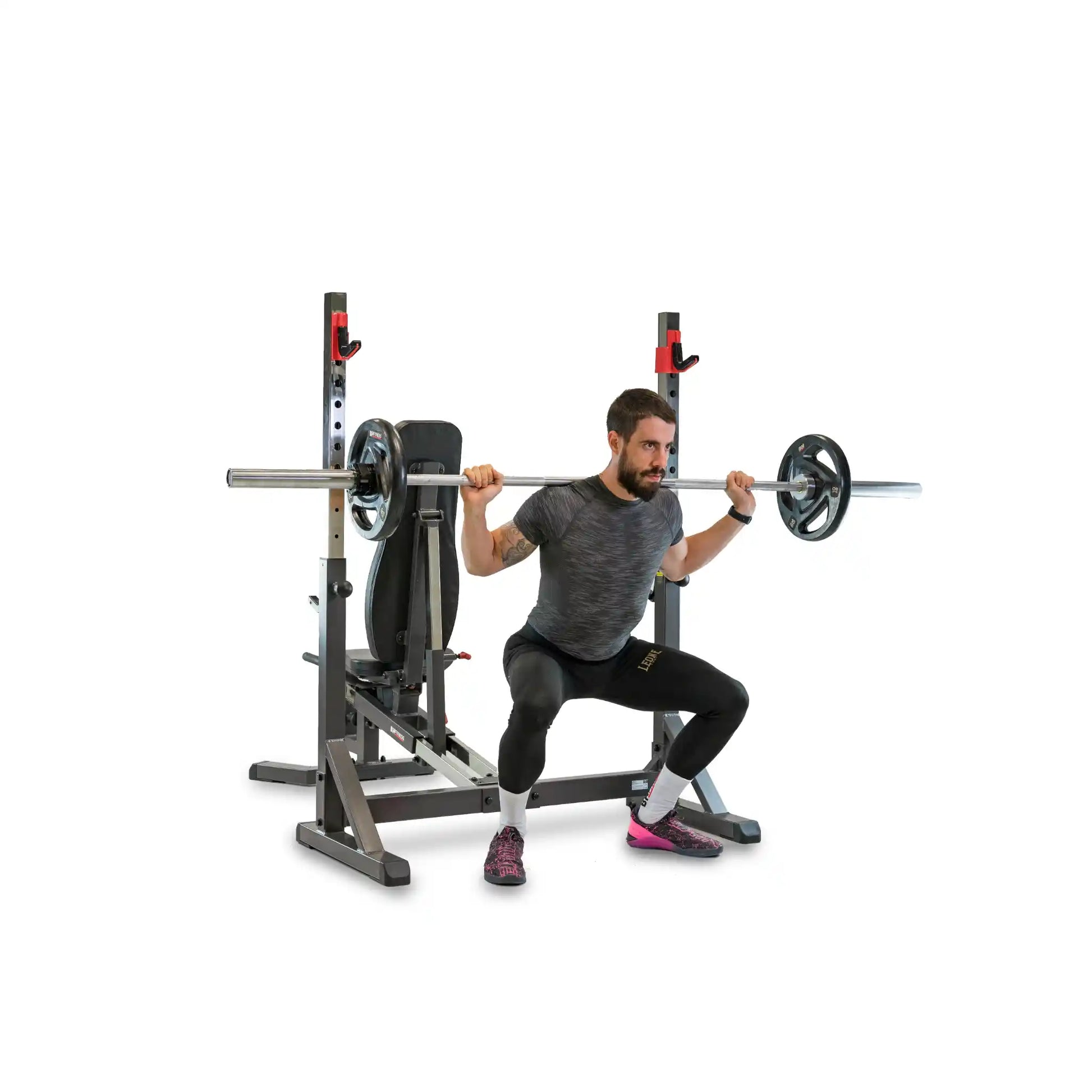 Man performing squats with a barbell on a weight rack.