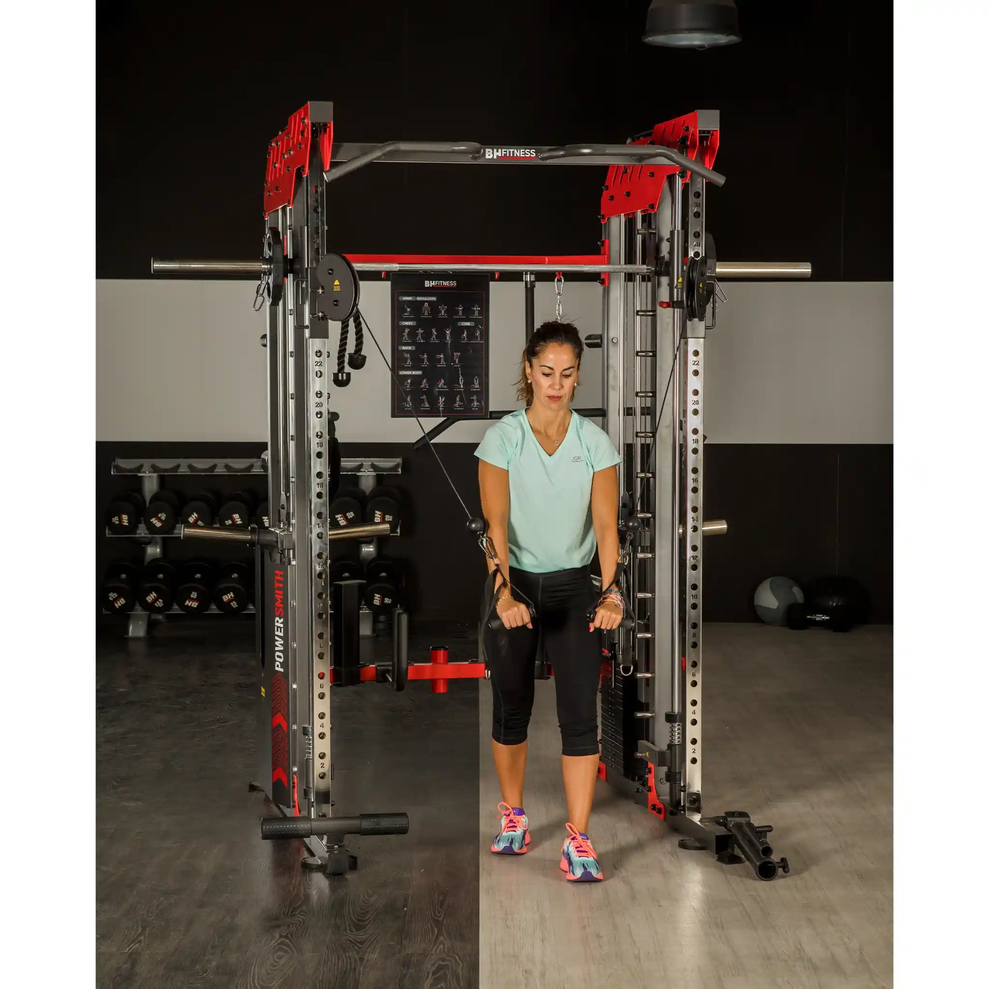 Woman using a pulling system on a multi gym in a gym setting