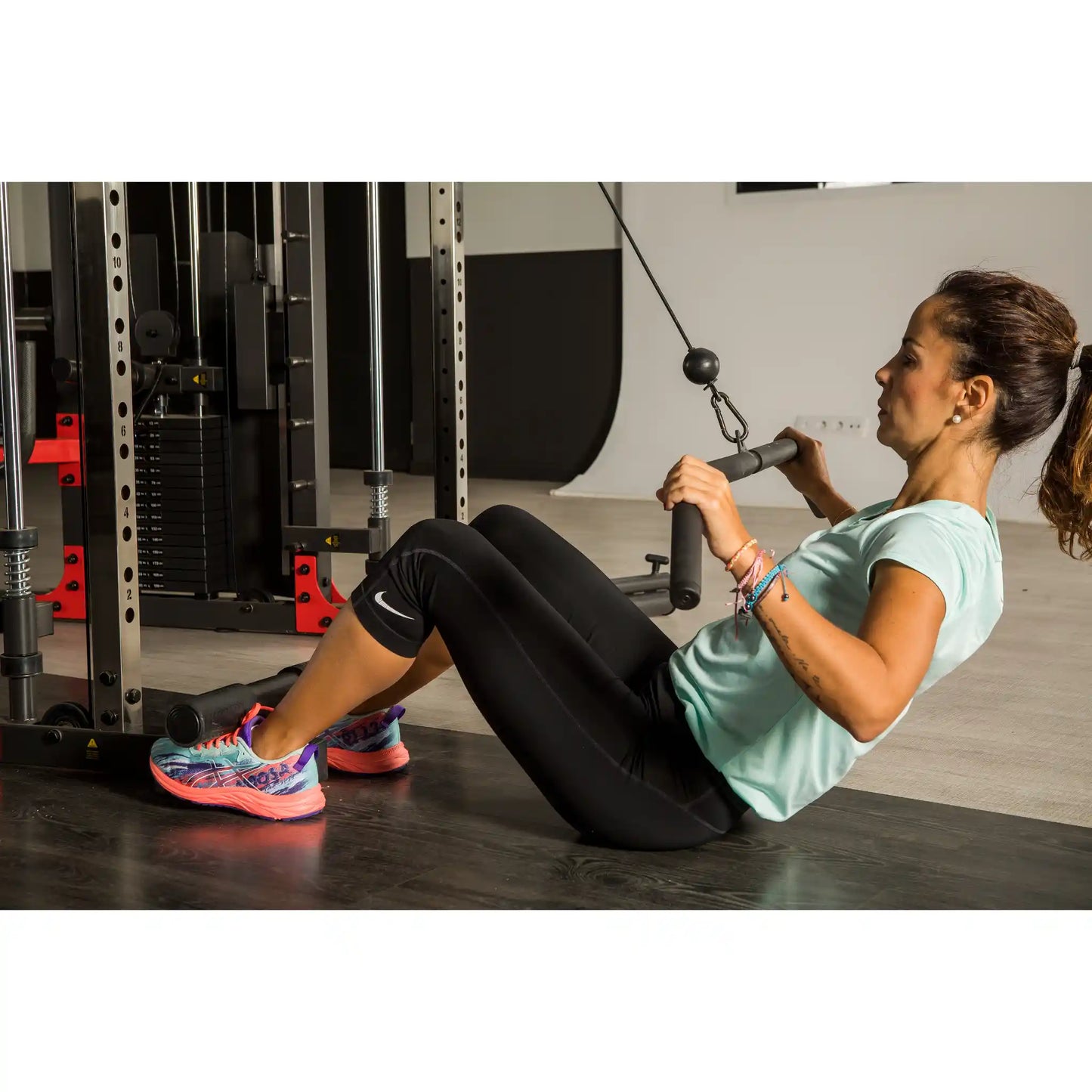 Woman exercising with pulley machine in a gym setting