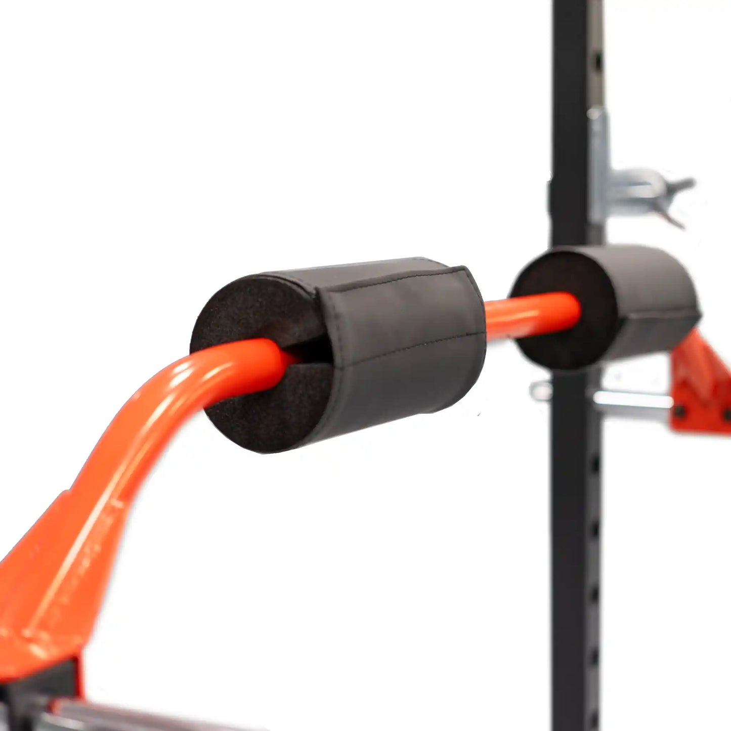 Orange bar attached to a black power cage attachment on a white background