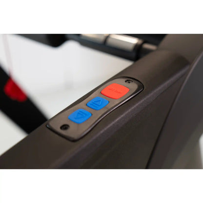 Close-up of a control panel with red and blue buttons on a treadmill.