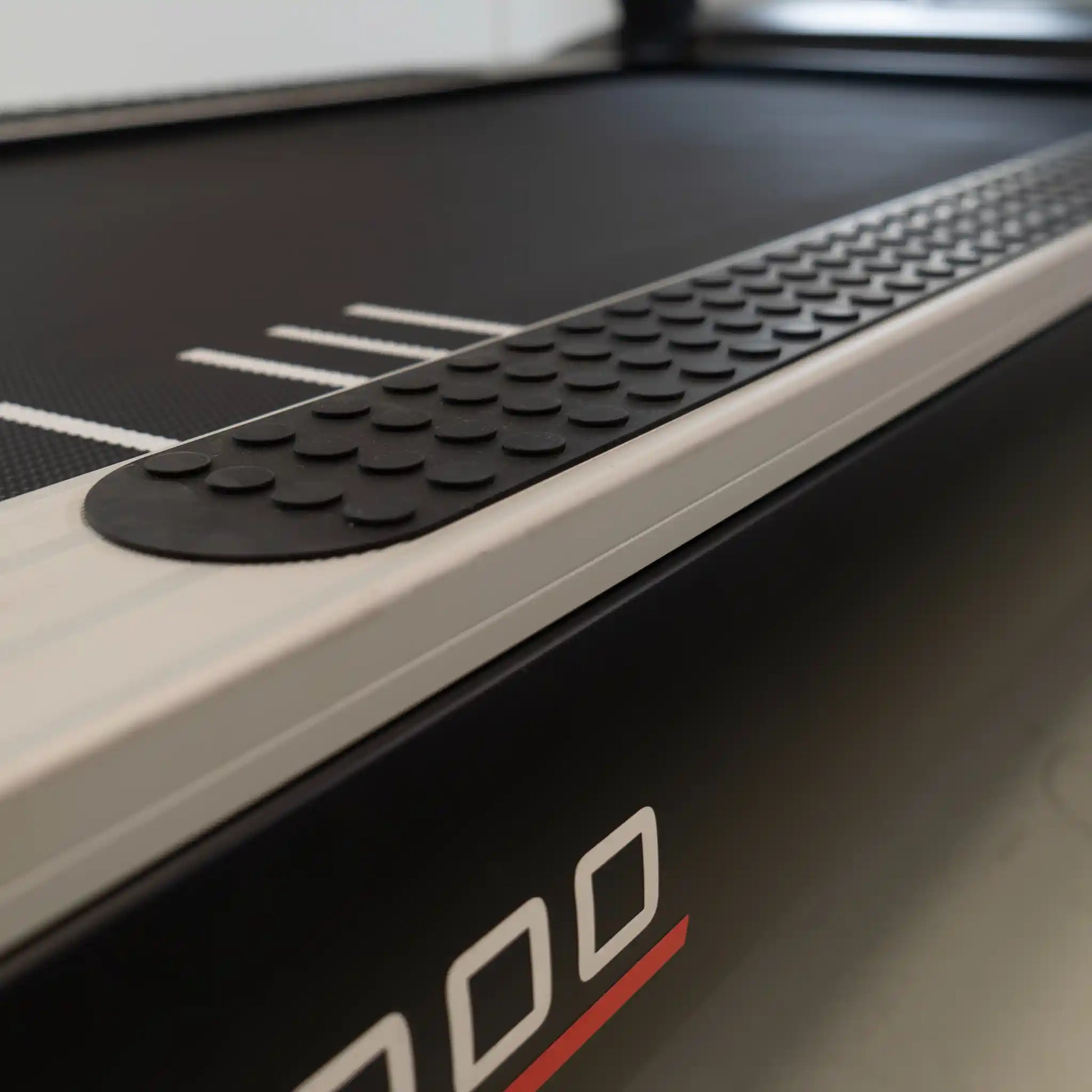 Close-up of a treadmill with a focus on the running belt and brand logo.