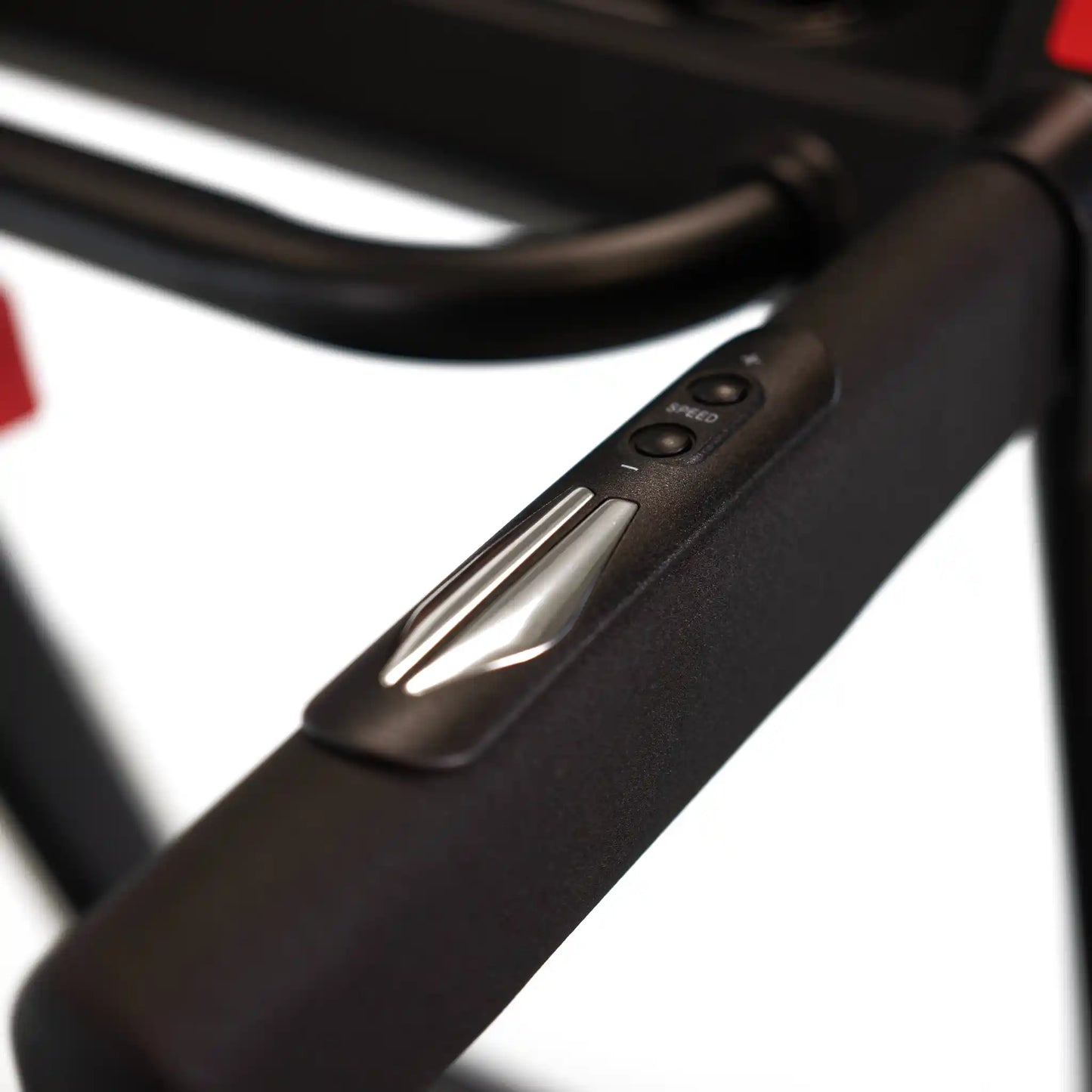 Close-up of a treadmill handlebar with control buttons on a blurred background