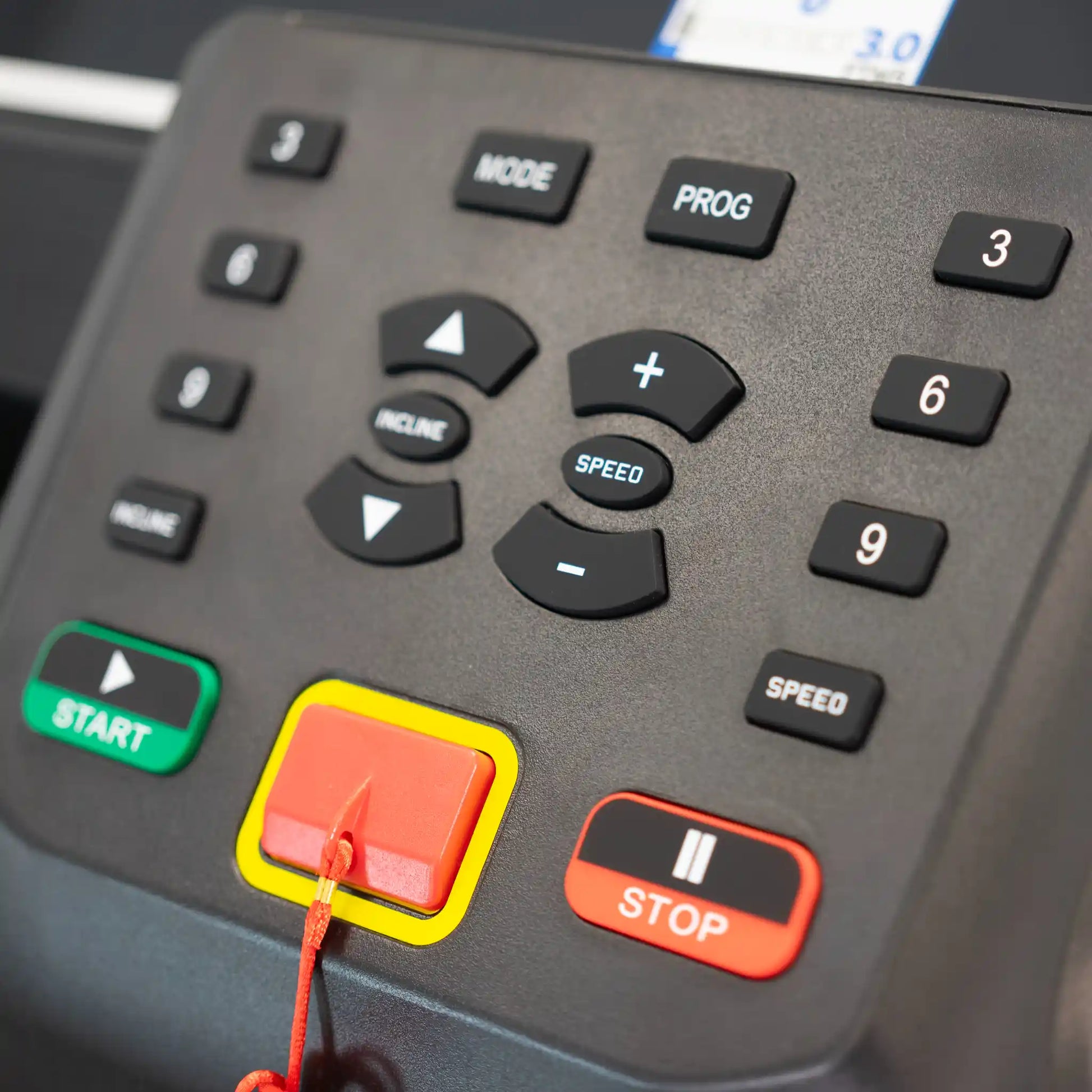 Control panel with buttons and a red button highlighted on a treadmill.