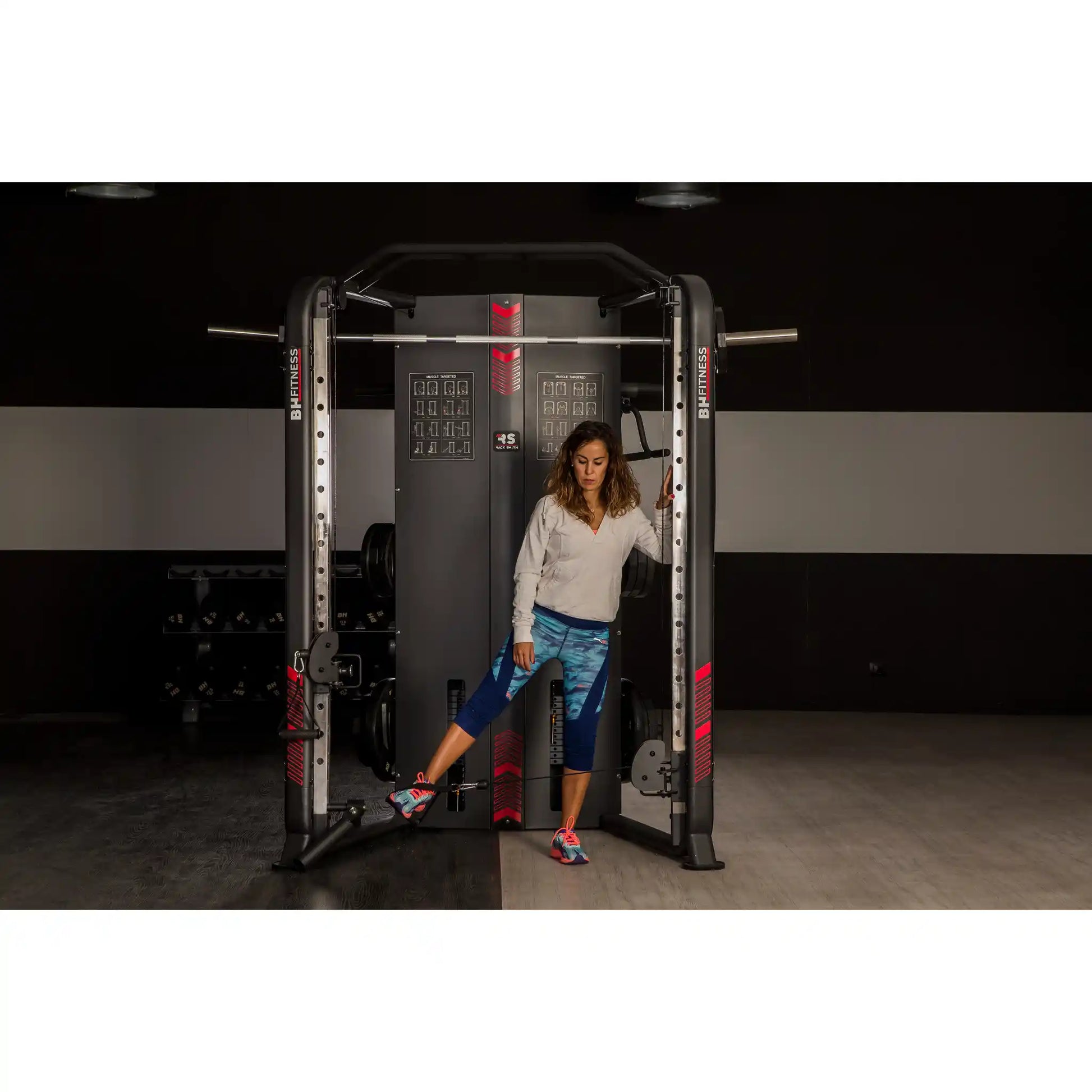 Woman using a pulley system on multi gym in a gym setting