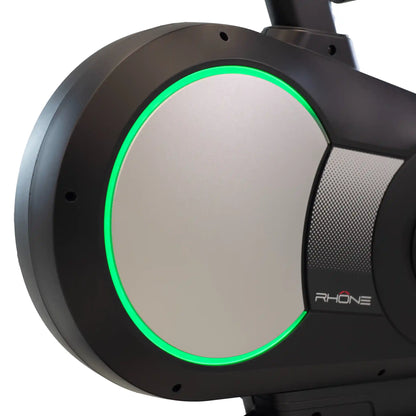 Close-up of exercise bike fly wheel with a green light on a white background