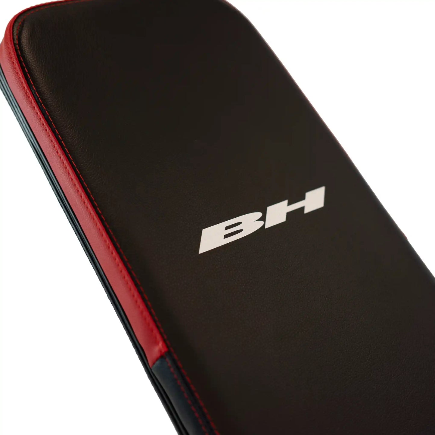 Back support on black and red weight bench with BH branding
