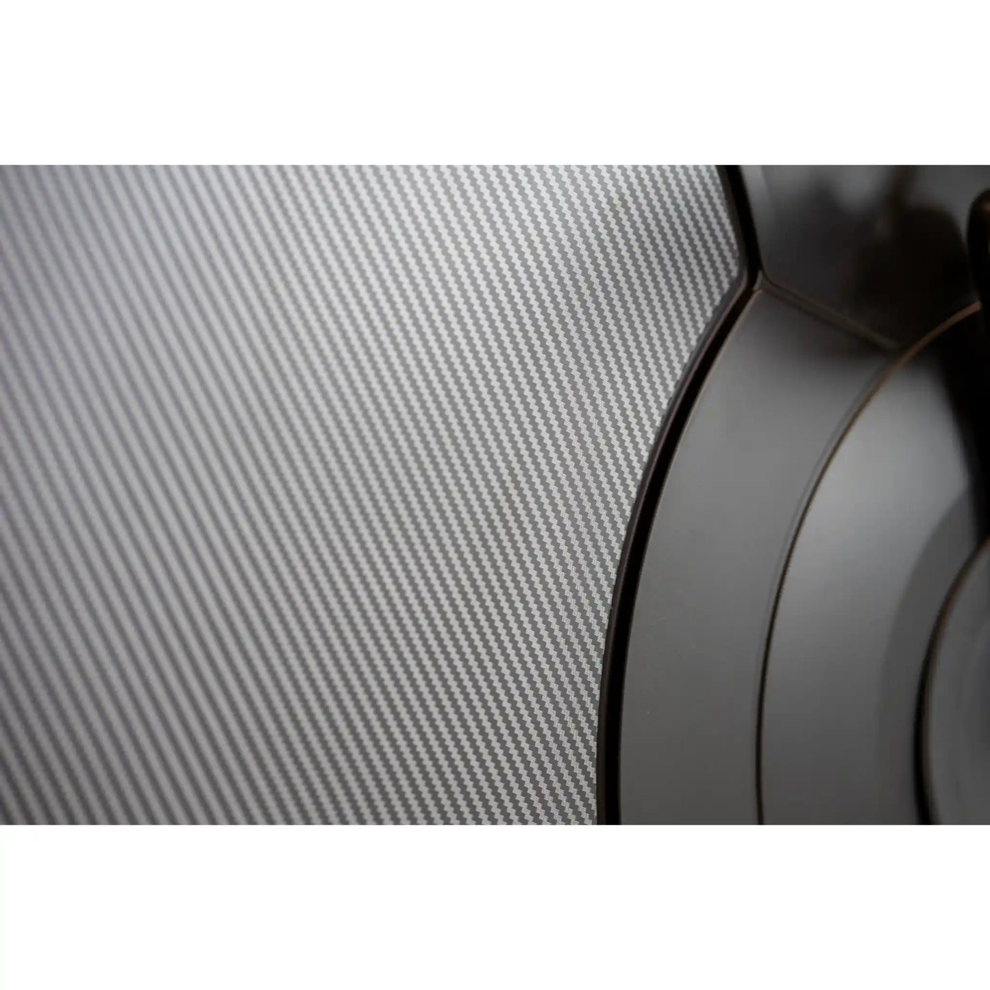 Close-up of a carbon fiber texture with a blurred object in the foreground