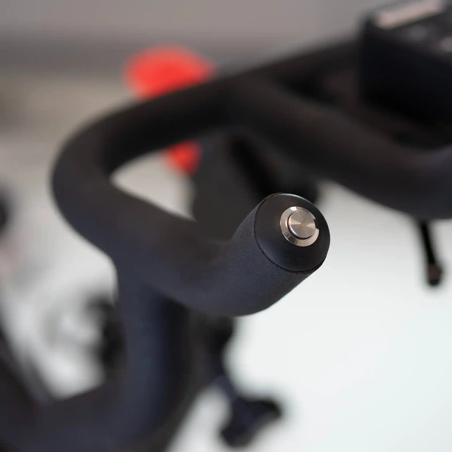 Close-up of exercise bike handlebar with a blurred background