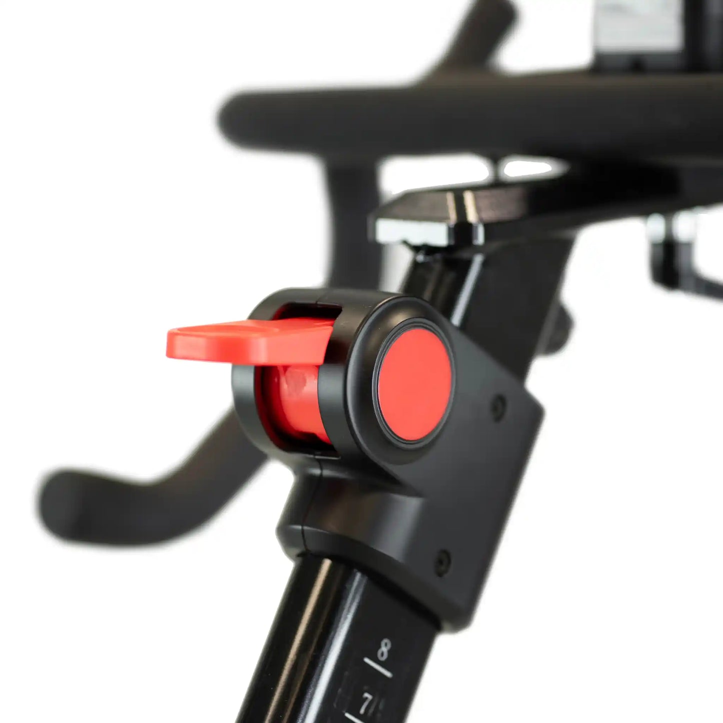 Close-up of a bicycle handlebar connector with red buttons on a blurred background
