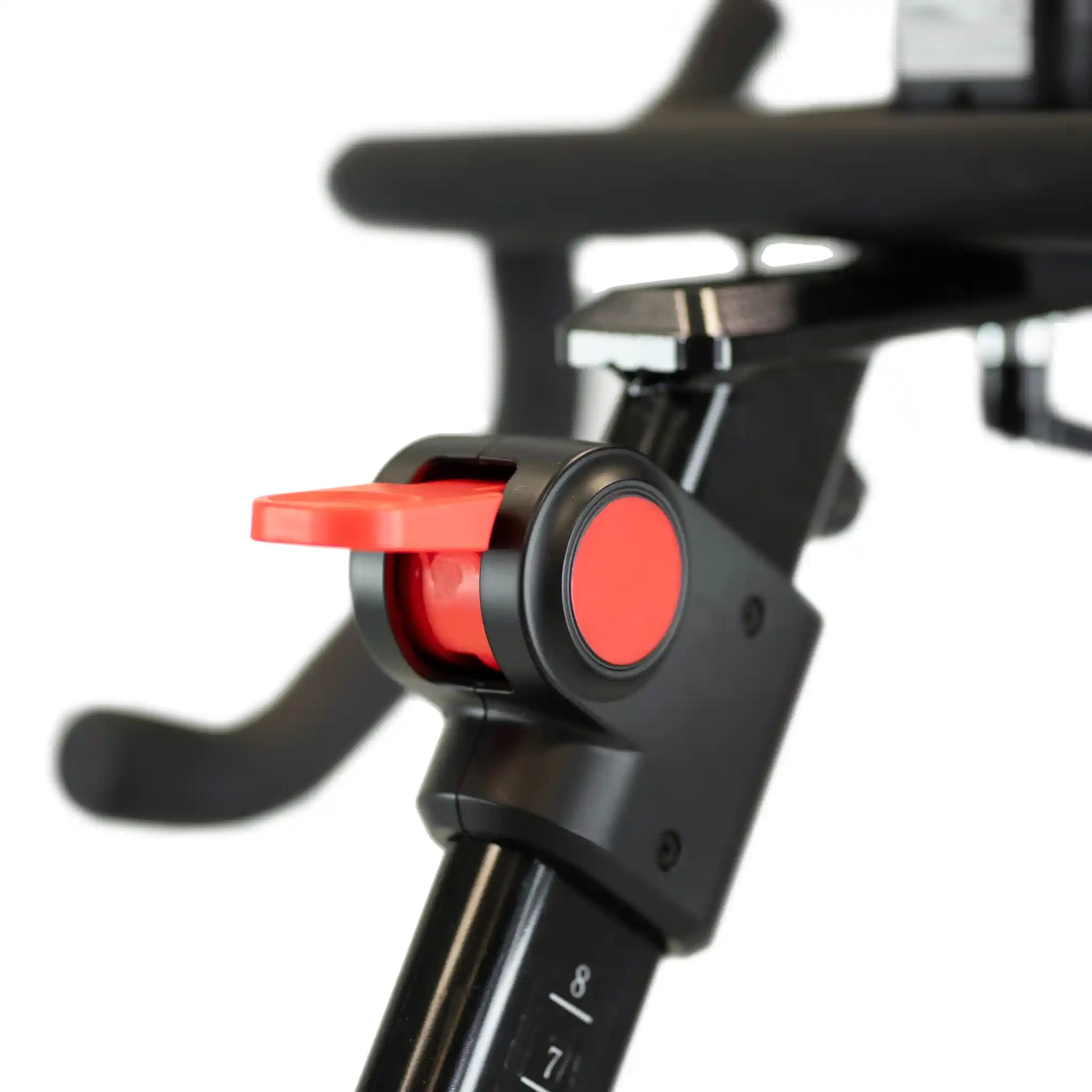 Close-up of a bicycle handlebar connector with red buttons on a blurred background