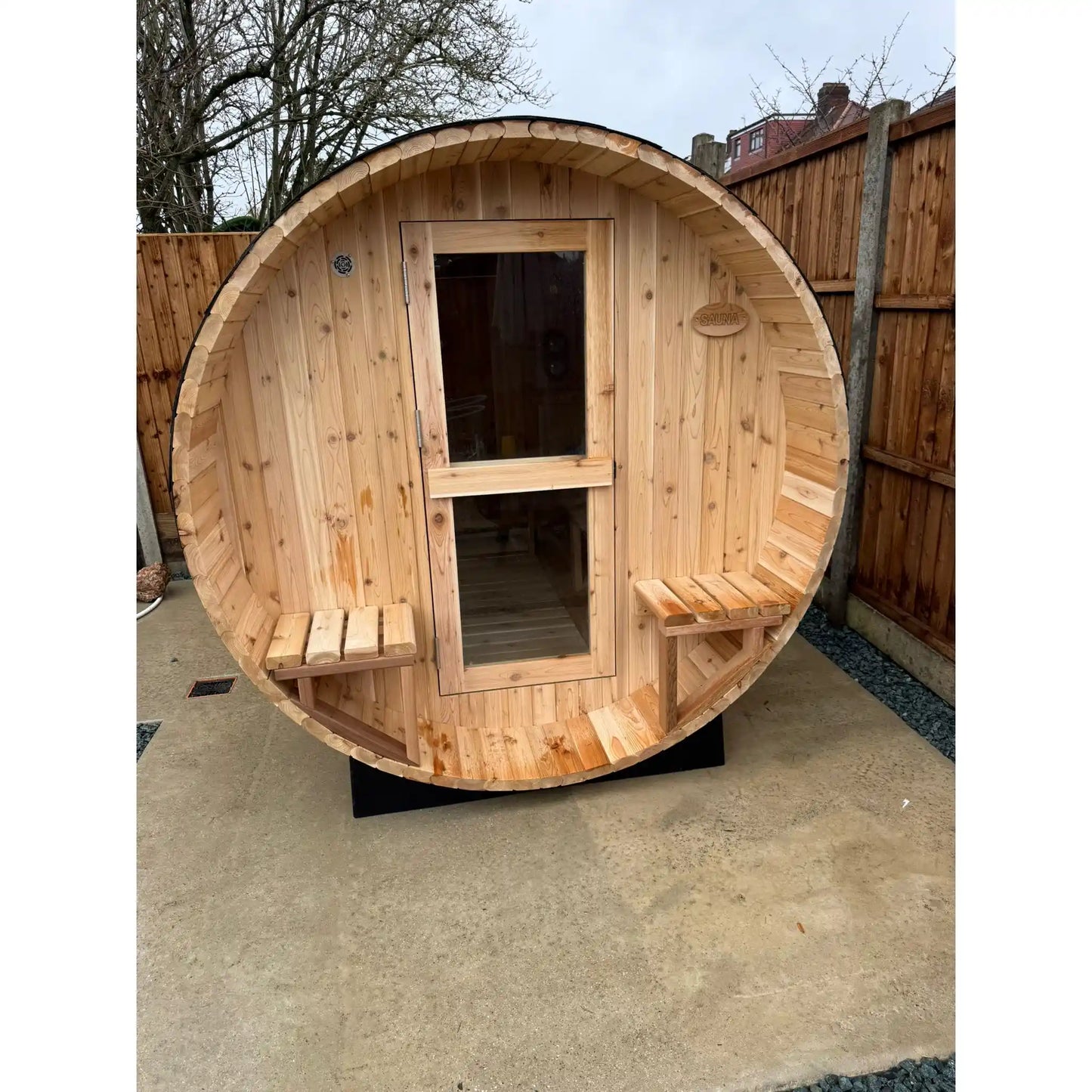 Wooden barrel-shaped sauna with benches on a concrete surface