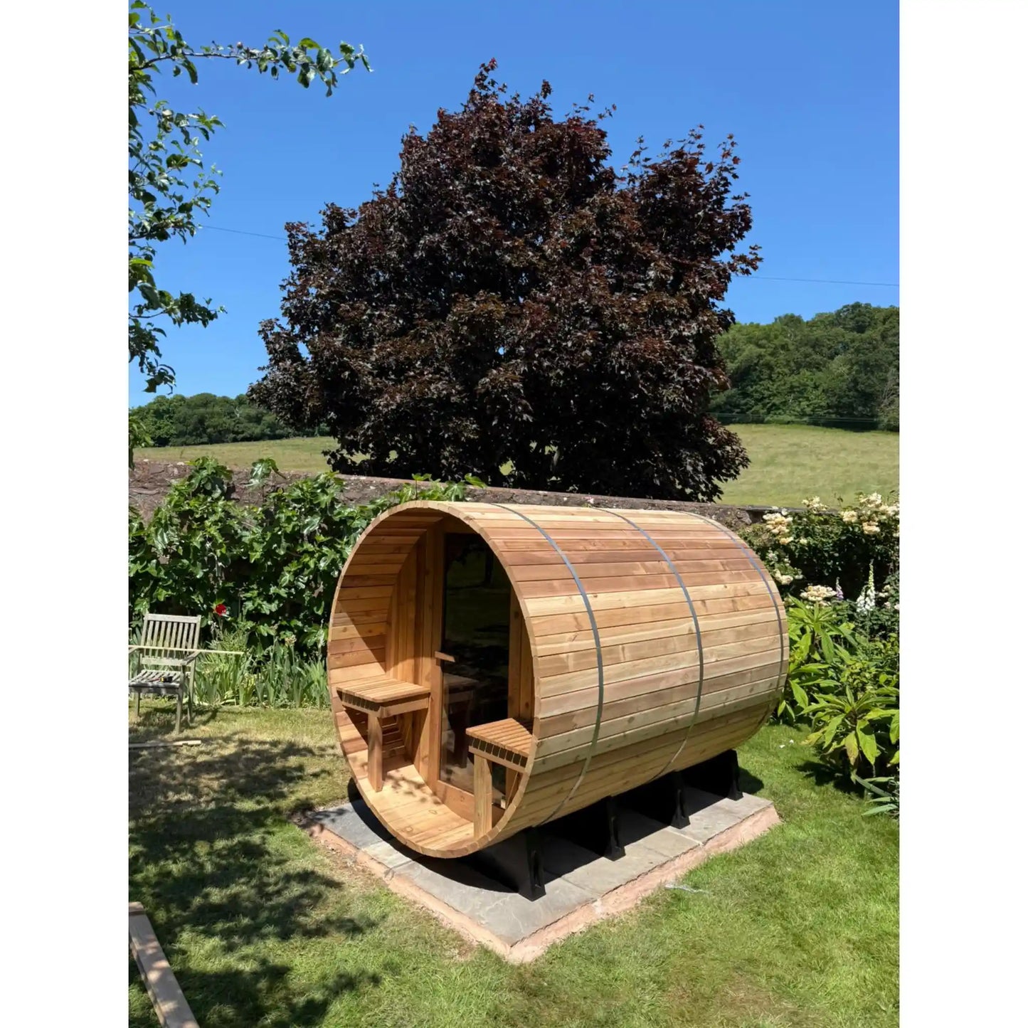 Wooden barrel sauna in a garden setting
