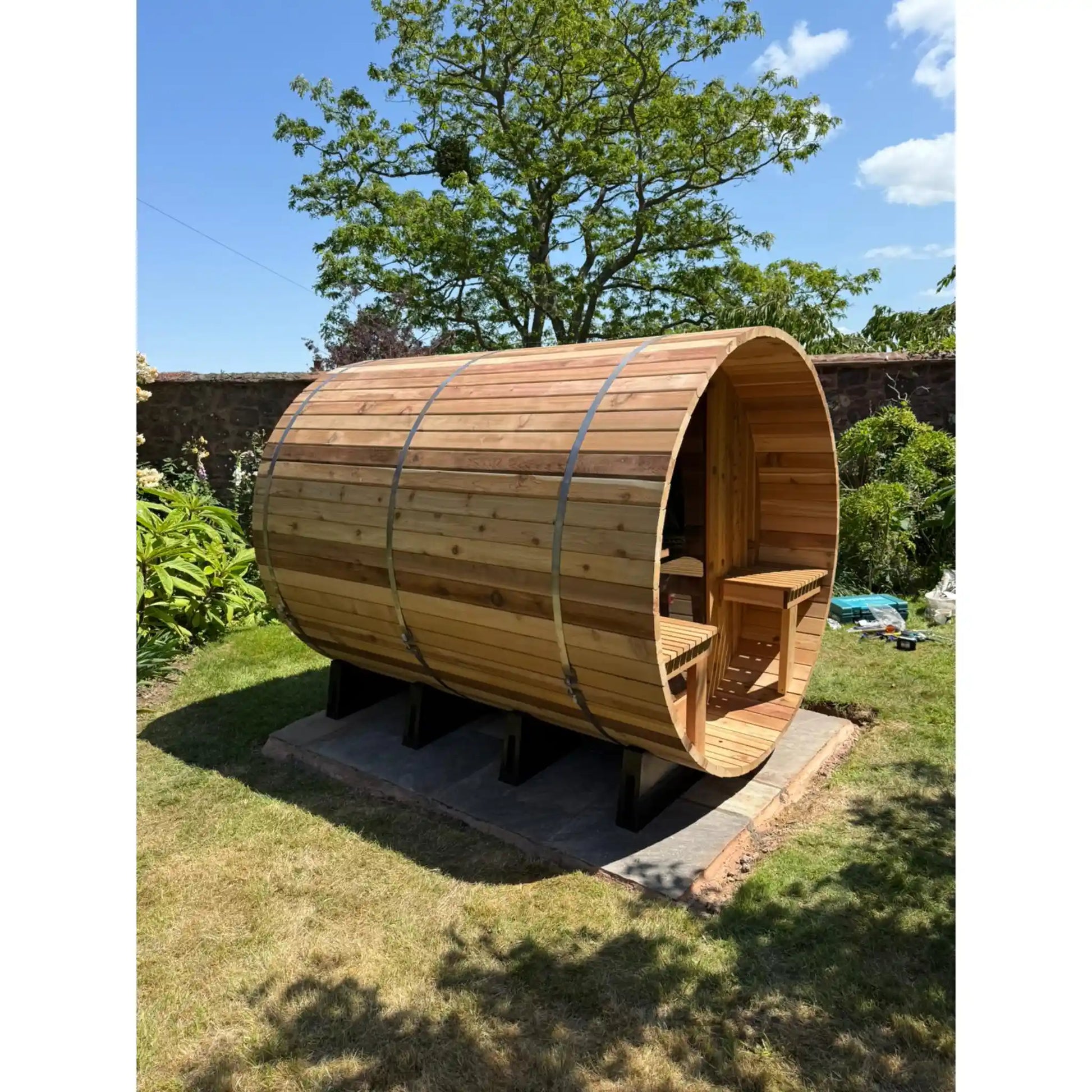 Wooden barrel sauna in a garden setting