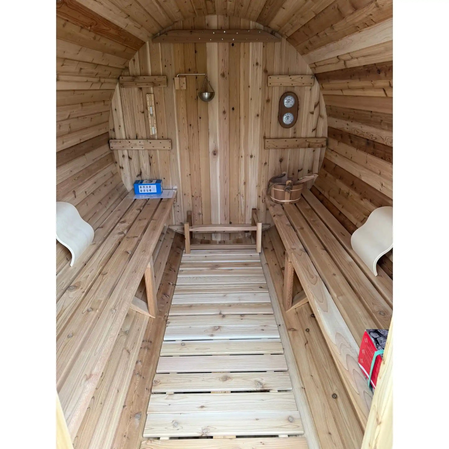 Wooden sauna with benches, thermometer, sand timer on the wall.