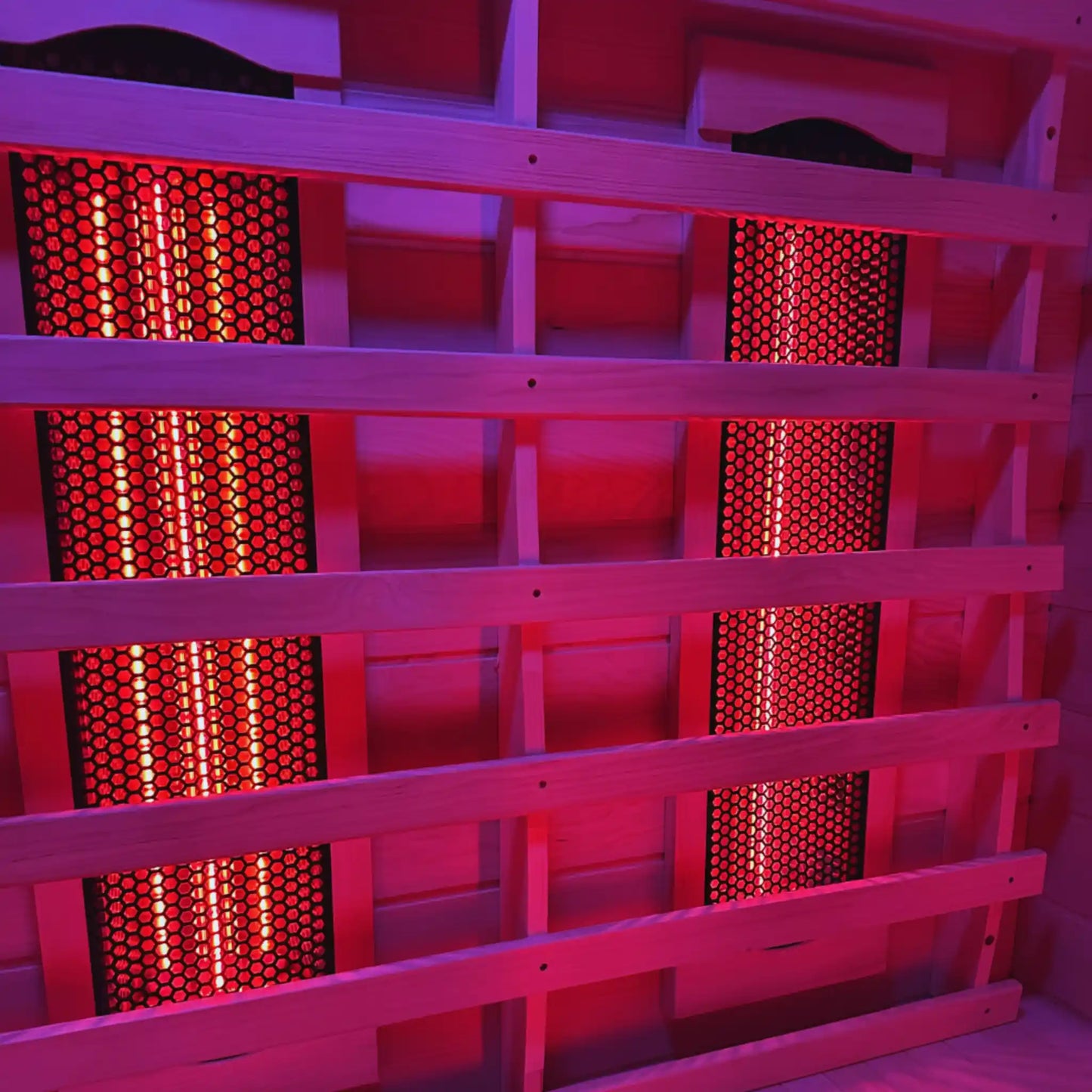 Wooden sauna with red light emitting from heating elements