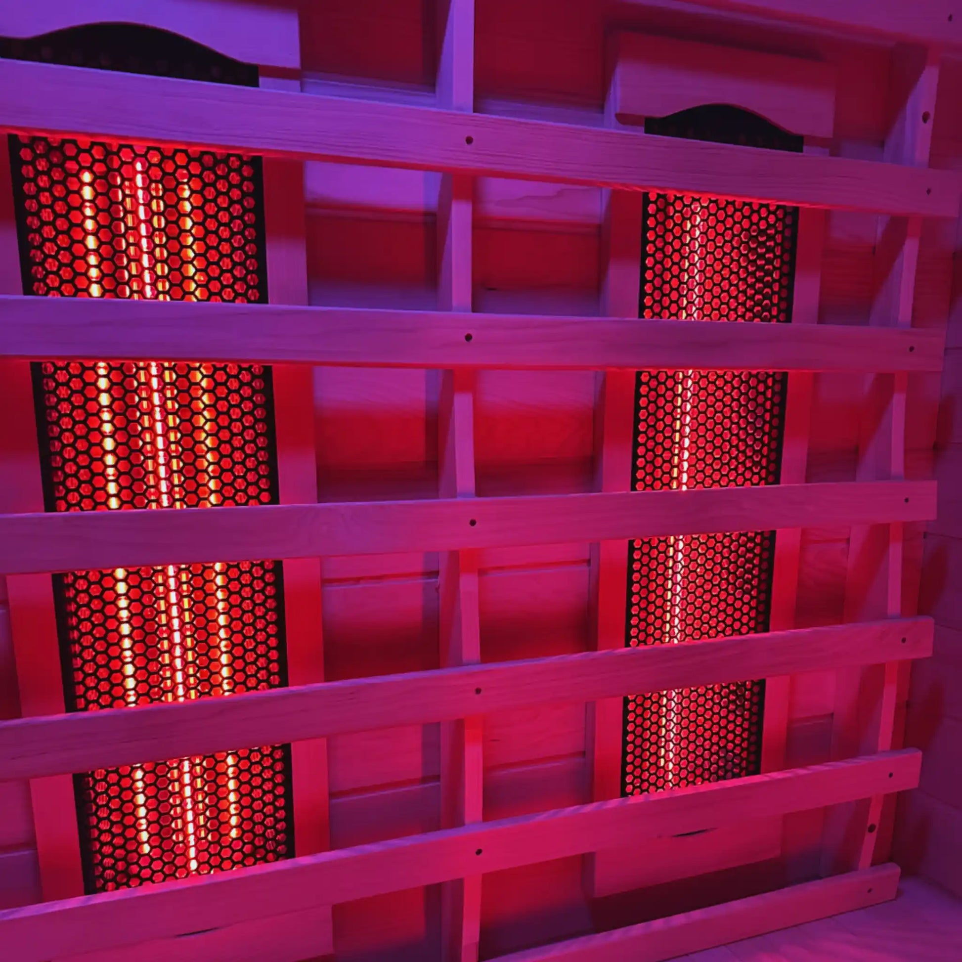 Wooden sauna with red light emitting from heating elements