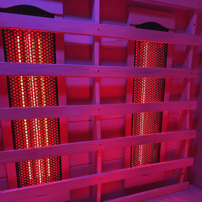 Wooden sauna with red light emitting from heating elements
