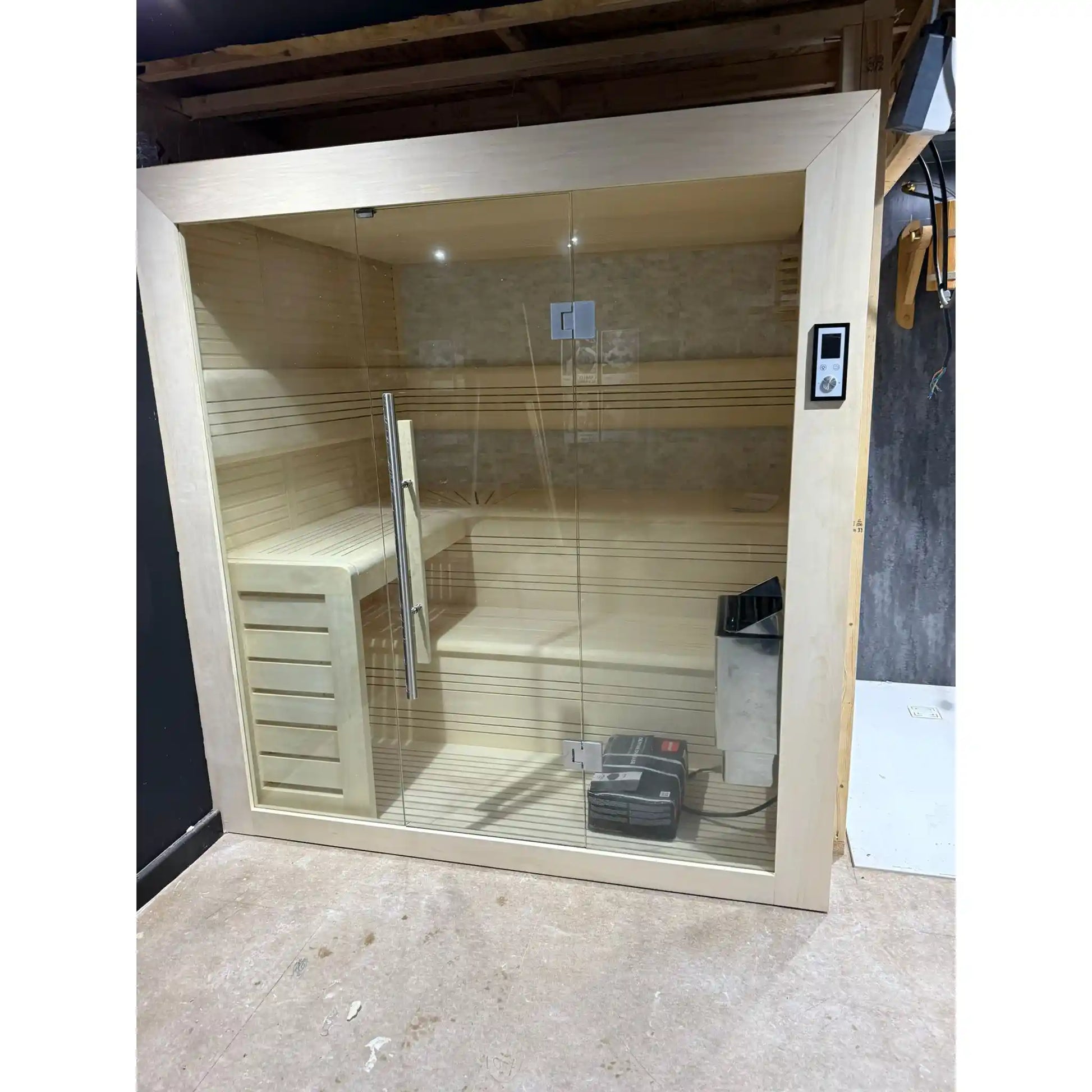 Infrared sauna with glass door and wooden interior in a room setting.
