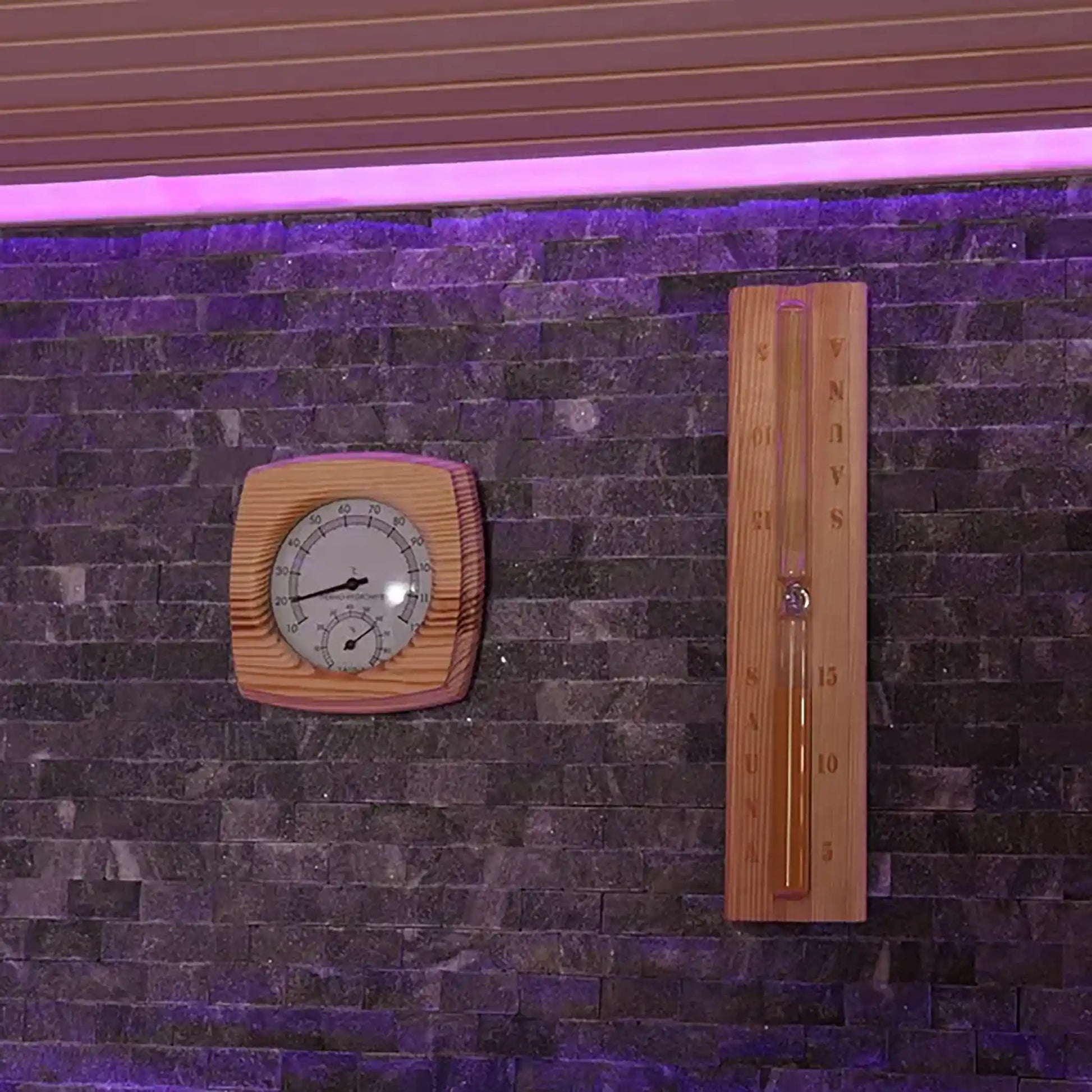 Wooden thermometer and hygrometer on stone wall inside a sauna