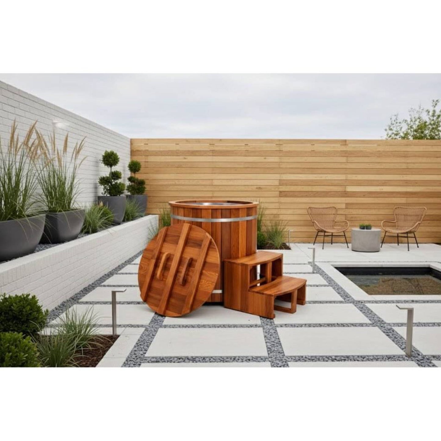 Wooden ice bath with steps in a modern outdoor setting with plants and a wooden fence.