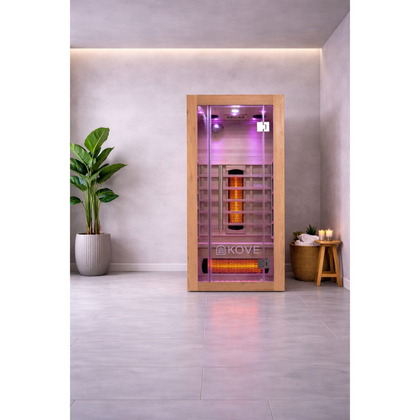 Infrared sauna with Kove logo in a modern room with a plant and candles.