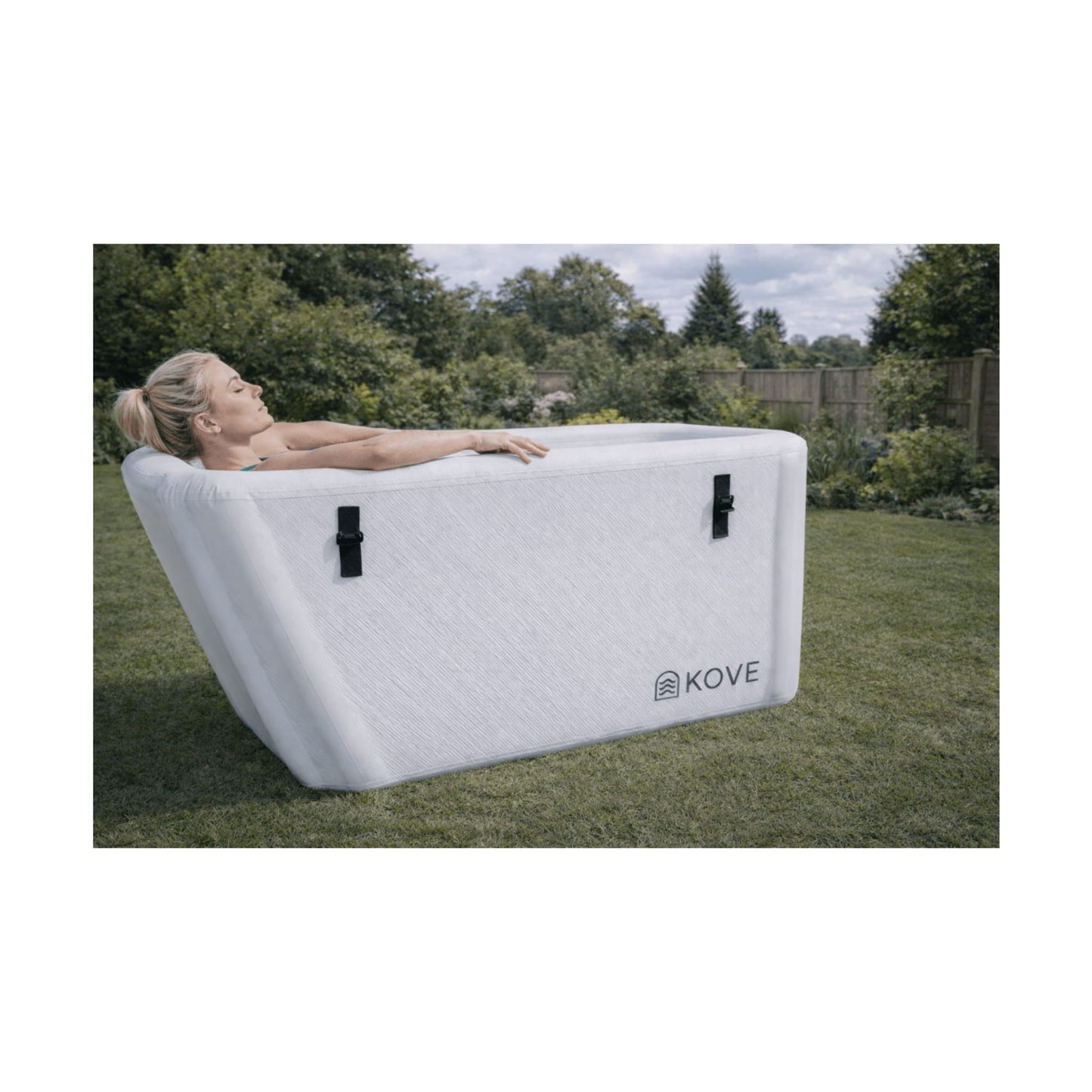 Lady laying in white Kove Elite Ice Bath in a garden