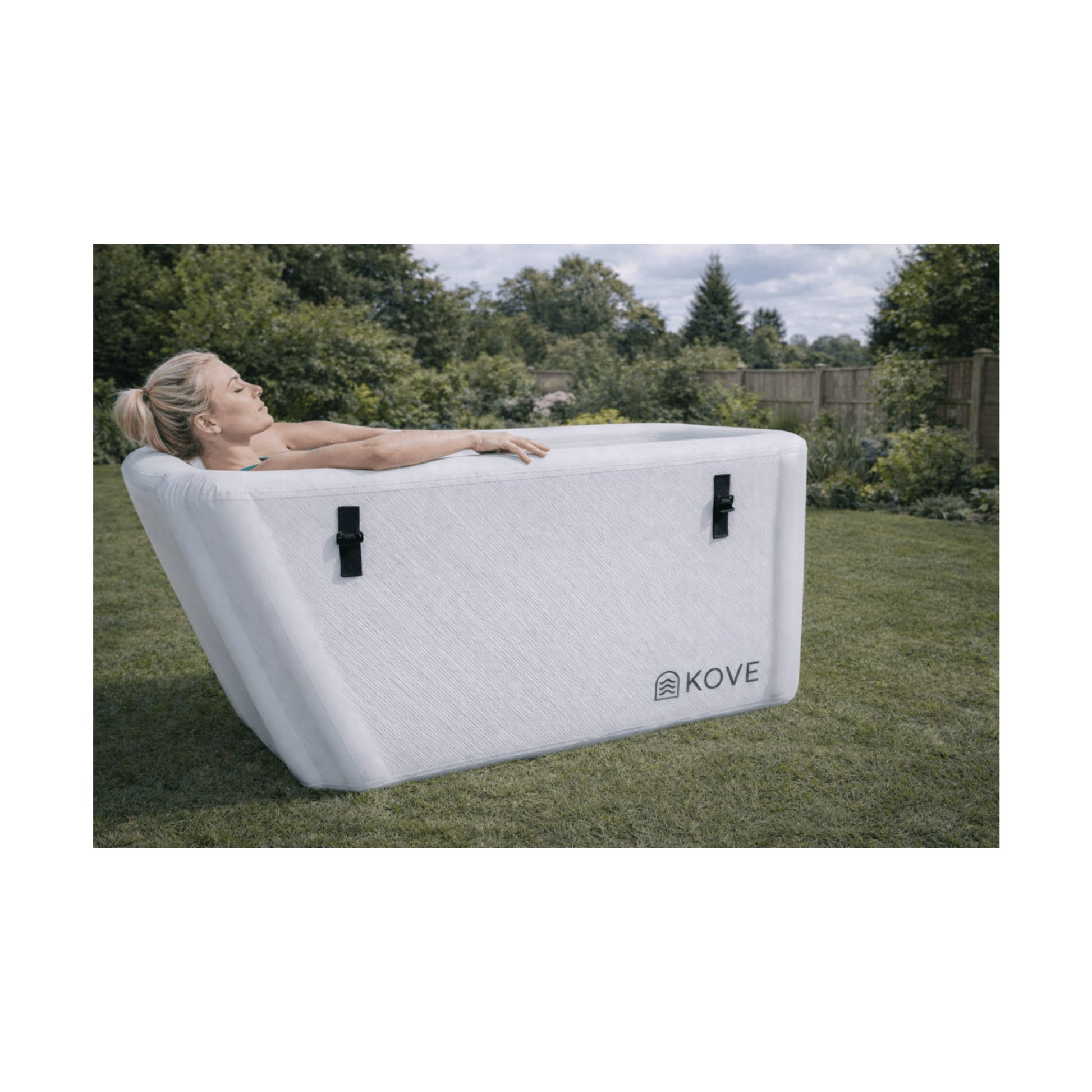 Lady laying in white Kove Elite Ice Bath in a garden