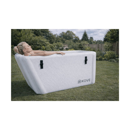Lady laying in white Kove Elite Ice Bath in a garden