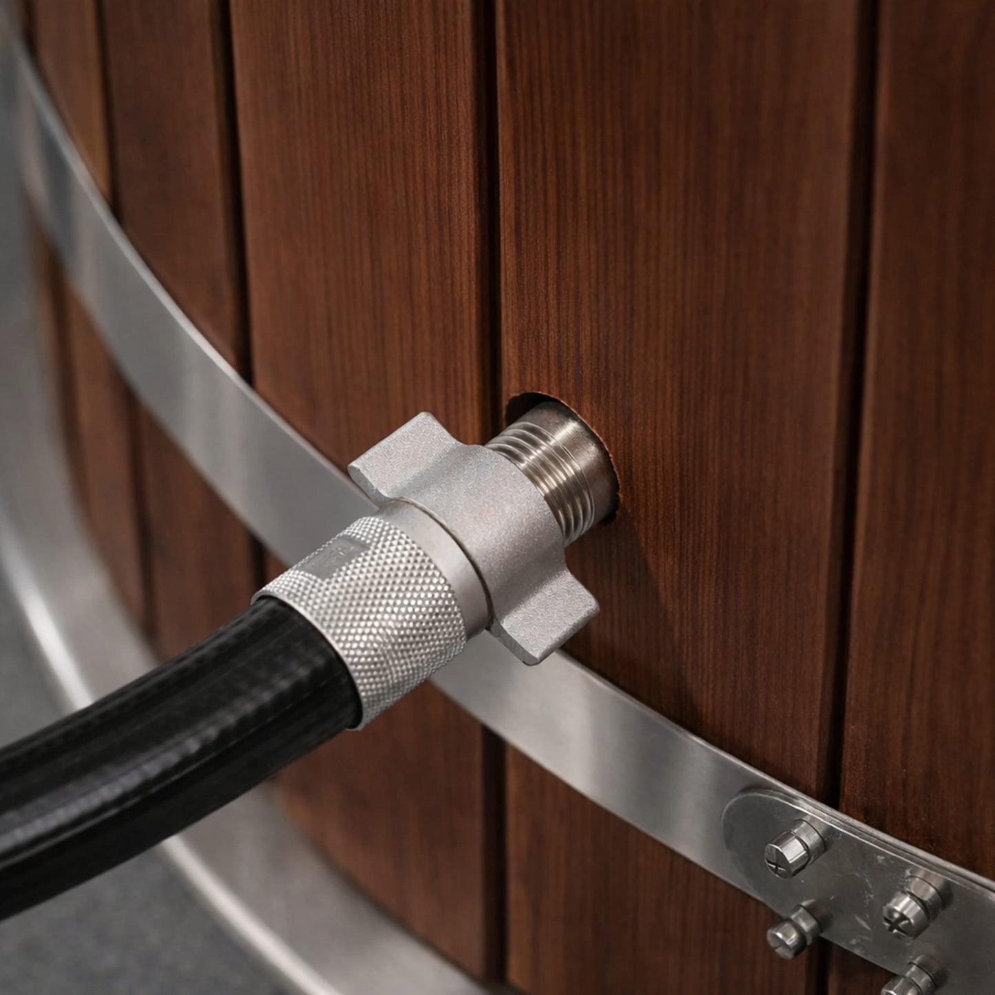 Close-up of a metal hose attachment from Kove Chiller to a wooden icebath