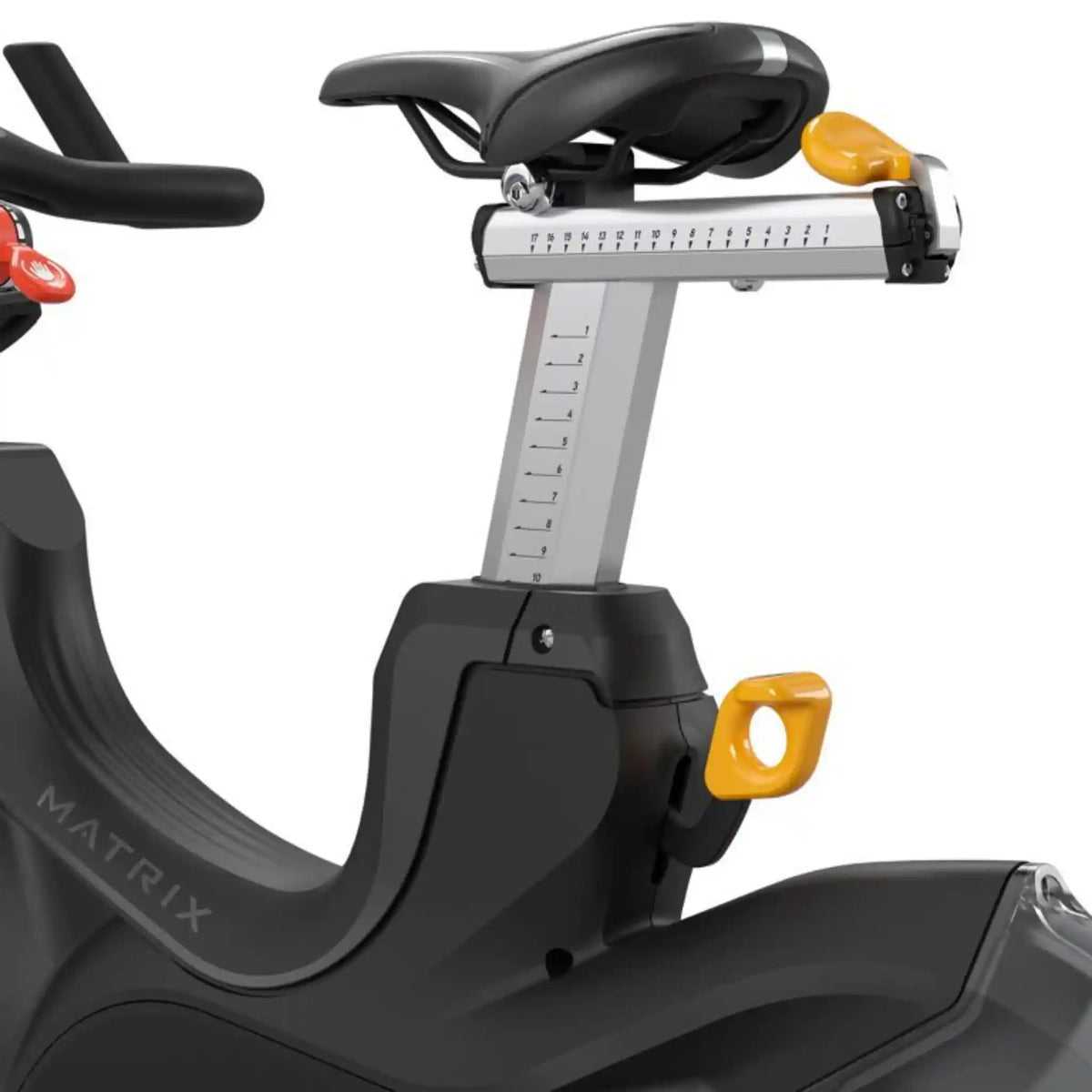 Close-up of a Matrix exercise bike showing the black saddle, silver seat post with measurement markings, yellow adjustment knobs, and the black seat tube with the MATRIX logo on a white background.